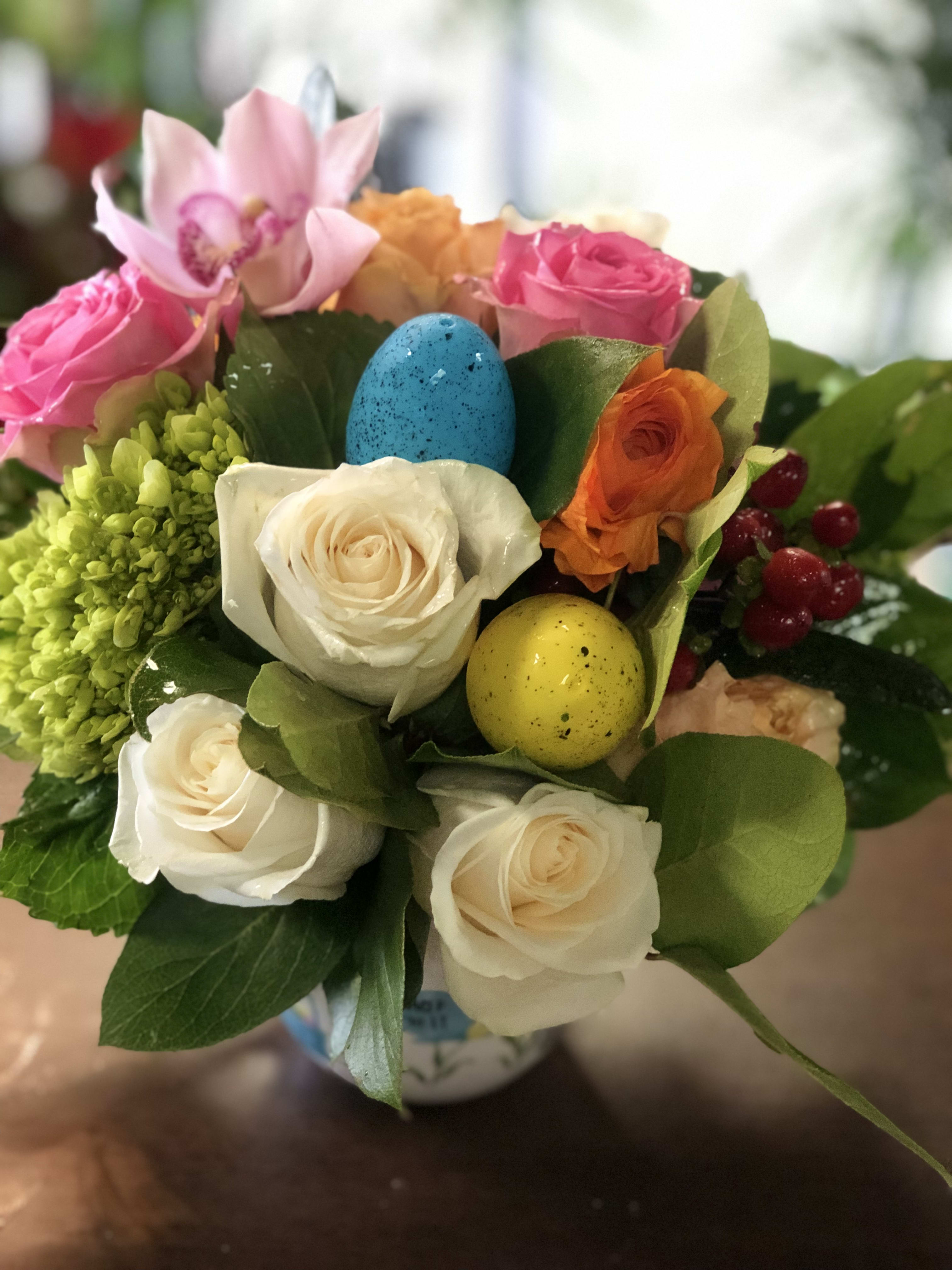 Hop To It  - Send Easter! We've taken the freshest blooms in pastel shades of pink, yellow and white with colorful Easter eggs for a playful surprise. Whether you're sending our charming bouquet as a gift for the holiday hostess, or making it the centerpiece at your own celebration, this truly original gift will have everyone hopping with delight!