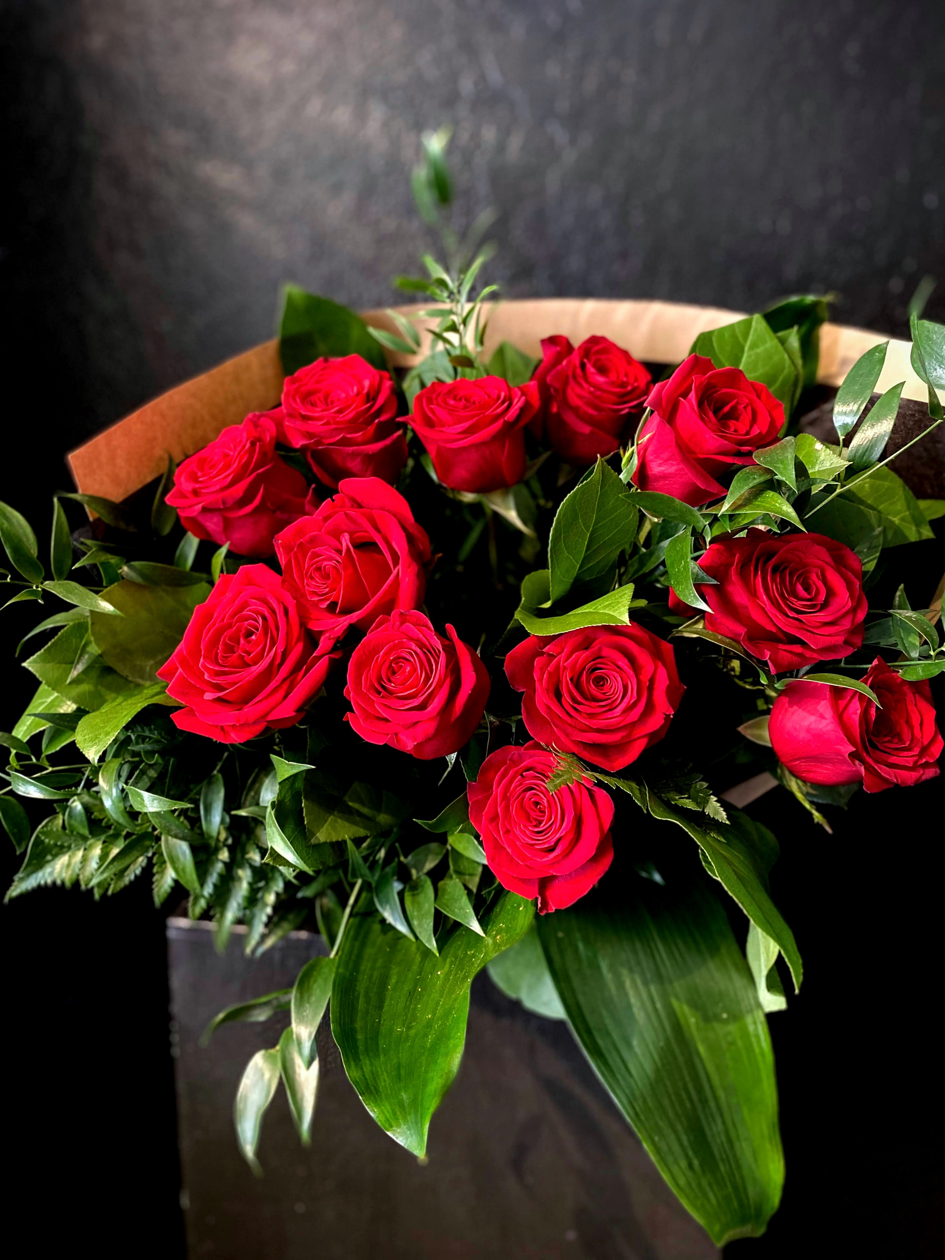 A Dozen Kisses - Our designers will make you a beautiful wrapped bouquet of a dozen roses. Default color will be red unless otherwise requested.