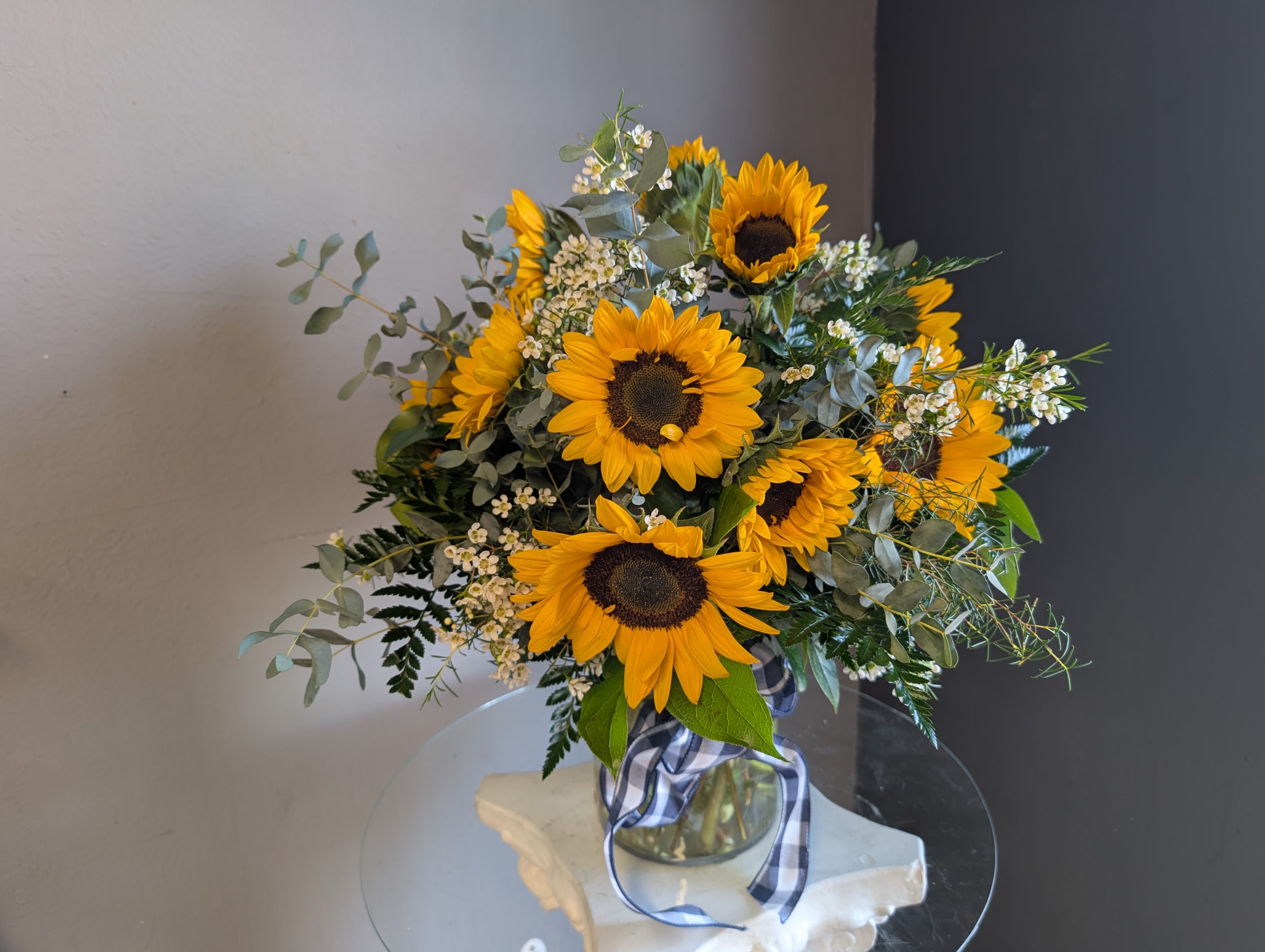 1 Dozen Sunflowers - This Arrangement will be made to order and each arrangement will look different. Filler, greens, ribbon, and vase will vary.
