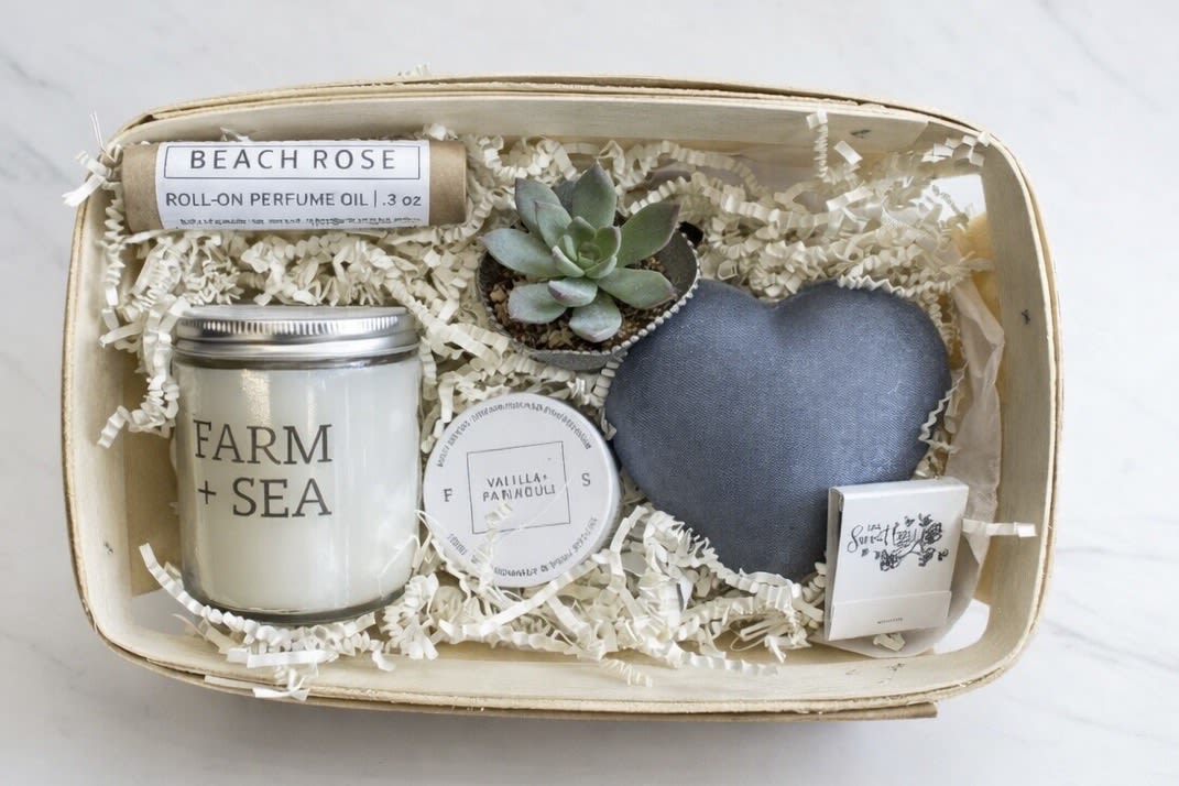 Farm &amp; Sea Care Package  - A gift basket full of goodies from our local favorite maker, Farm + Sea.  A roll-on perfume oil, 5.5 oz candle, and a 2 oz. body lotion all in our favorite season scents.  Ask about specific scents if you like!  These items are packaged in our signature craft box along with a puffed decorative heart and petite fresh succulent plant.   FARM + SEA began with owner Mary Swenson’s obsession with cultivating a cozy, inviting home filled with meaningful objects. Inspired by her beloved New England, and the utilitarian beauty of farms and the transformative power of the sea that uniquely defines this area, Mary set out to create a brand that uses the power of scent to evoke a memory, to create a mood, and to uplift  and relax, in vessels that reflect a clean and modern New England vibe.  Produced in our production studio in Amesbury, Massachusetts, our products are made in small batches using quality ingredients and carefully chosen scents that change seasonally.    Please note: if any item is unavailable, we will replace it with a similar seasonal item of equal or greater value.
