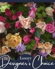 Luxury Designer’s Choice  - A lush cascade of mixed roses, ruffled carnations, and cheerful high end flowers  in pink, peach, yellow and soft lavender-this luxury designer's choice flower arrangement makes an unmistakable statement for anniversaries, milestone celebrations, or romantic gestures. The close-set composition and bold color blocking create an immediate visual impact that will make the person you're thinking of feel celebrated and truly seen.  Hand-styled for a full, opulent silhouette, the bouquet layers large rose blossoms with textured high end seasonal flowers to deliver depth and movement. The palette moves from warm peach and pinks into sunny yellow highlights and gentle purple accents, complemented by fresh green foliage for contrast. The dense, garden-inspired construction reads as premium and custom-ideal when you want a standout floral gift without specifying every stem.  Perfect for marking important occasions or simply brightening someone's day, this arrangement is designed to arrive lush and ready to display. Because it's a designer's choice, each version is uniquely composed from the same luxurious color story and flower types to ensure freshness and seasonal variety-select your size at checkout to match the moment you're celebrating.