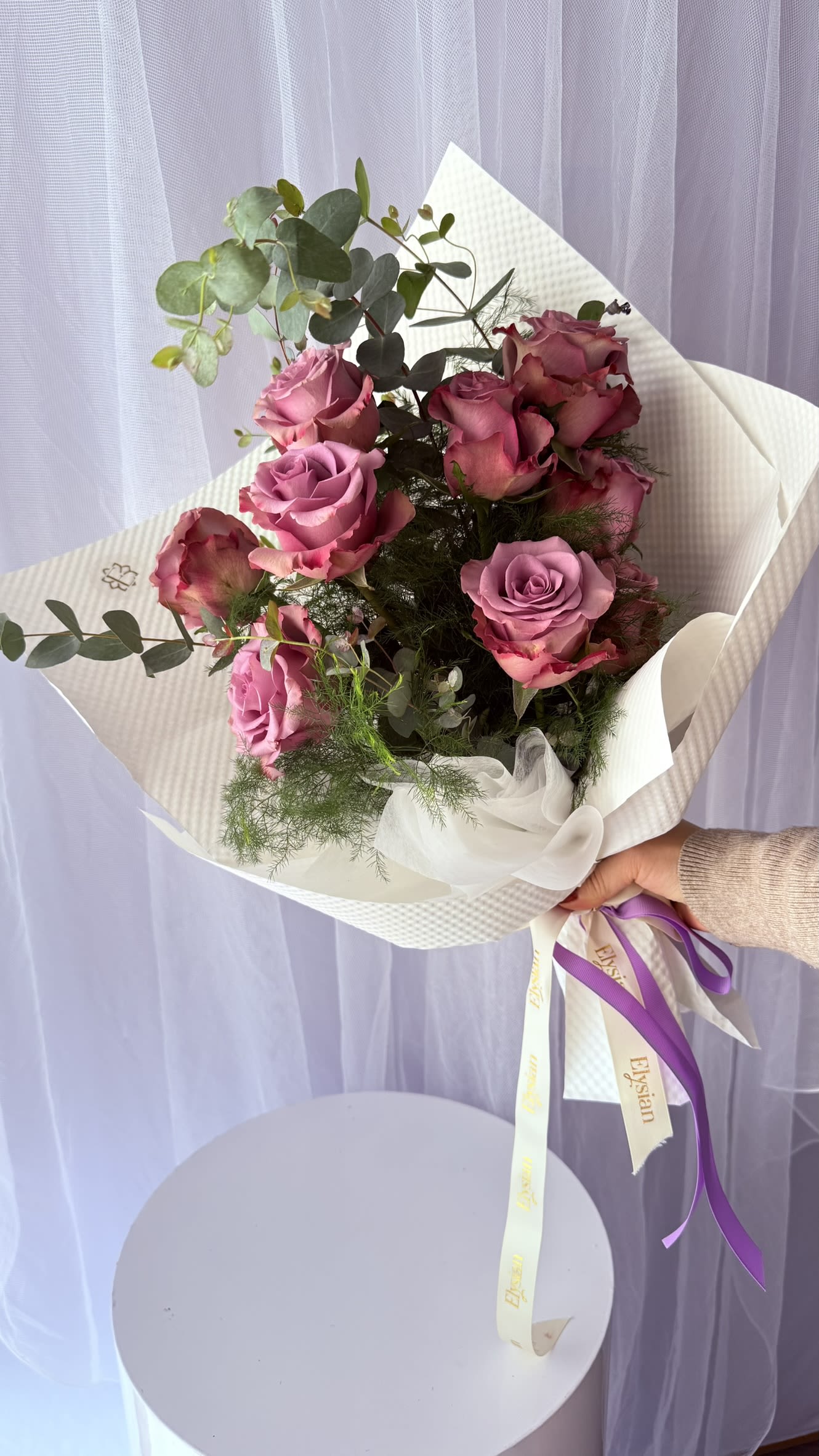 Enchanted Love - Perfect for anniversaries, birthdays, Valentine’s Day, or simply to say I’m thinking of you, this arrangement brings a sense of calm luxury and timeless beauty to any moment.  Each stem is carefully selected to create natural movement, allowing the layered rose tones to shine while the foliage adds softness and depth.  What’s included: • Premium Ecuadorian roses • Seasonal greenery and textural accents • Elegant designer wrapping with ribbon • Hand-tied and ready to gift  Care tip: Trim stems, place in fresh water, and keep away from direct sunlight to extend vase life.  Disclaimer: Rose shades may vary slightly due to seasonal availability, while maintaining the same overall color palette and style.