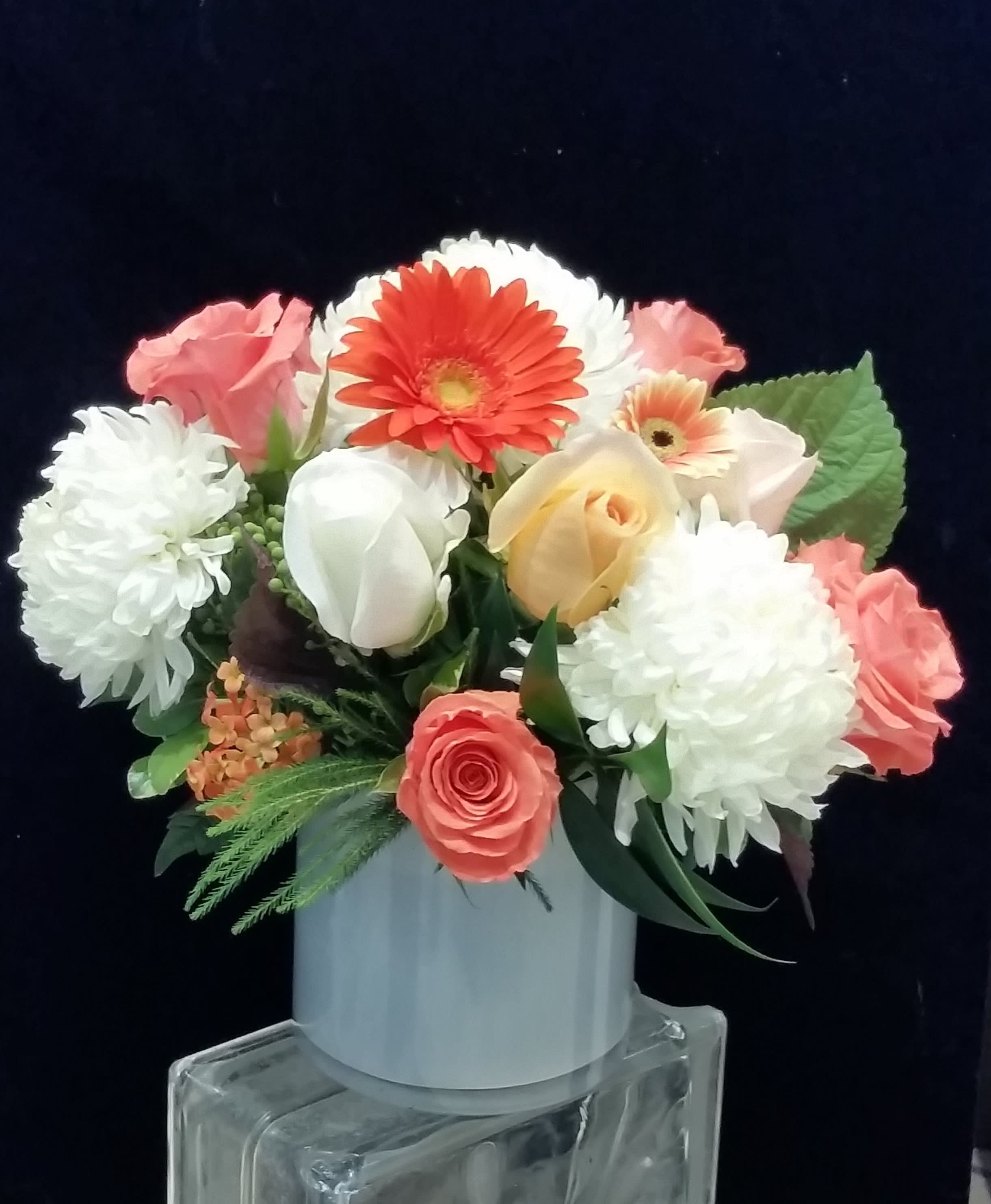 Creamsicle - Either you remember the wonderful taste of the orange Creamsicle ice cream pop, one of my ffrozen favorites as a kid, or you are too young to even know what a Creamsicle is! Nonetheless, suffice it to say that the refreshing taste of fresh oranges combined with the rich texture and flavor of sweet cream made the Creamsicle a favorite of the day.  This vivid combination of premium roses, Gerbera Daisies and football mums looks inviting, exciting and delicious just like the frozen treat did!