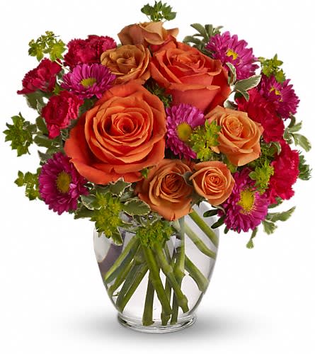 Tiki Party - Bright, festive orange and fuchsia roses, matsumoto asters and hot pink miniature carnatioins create this happy, vibrant arrangement.  It's like a beach party in a vase! Approximately 10" x 12"