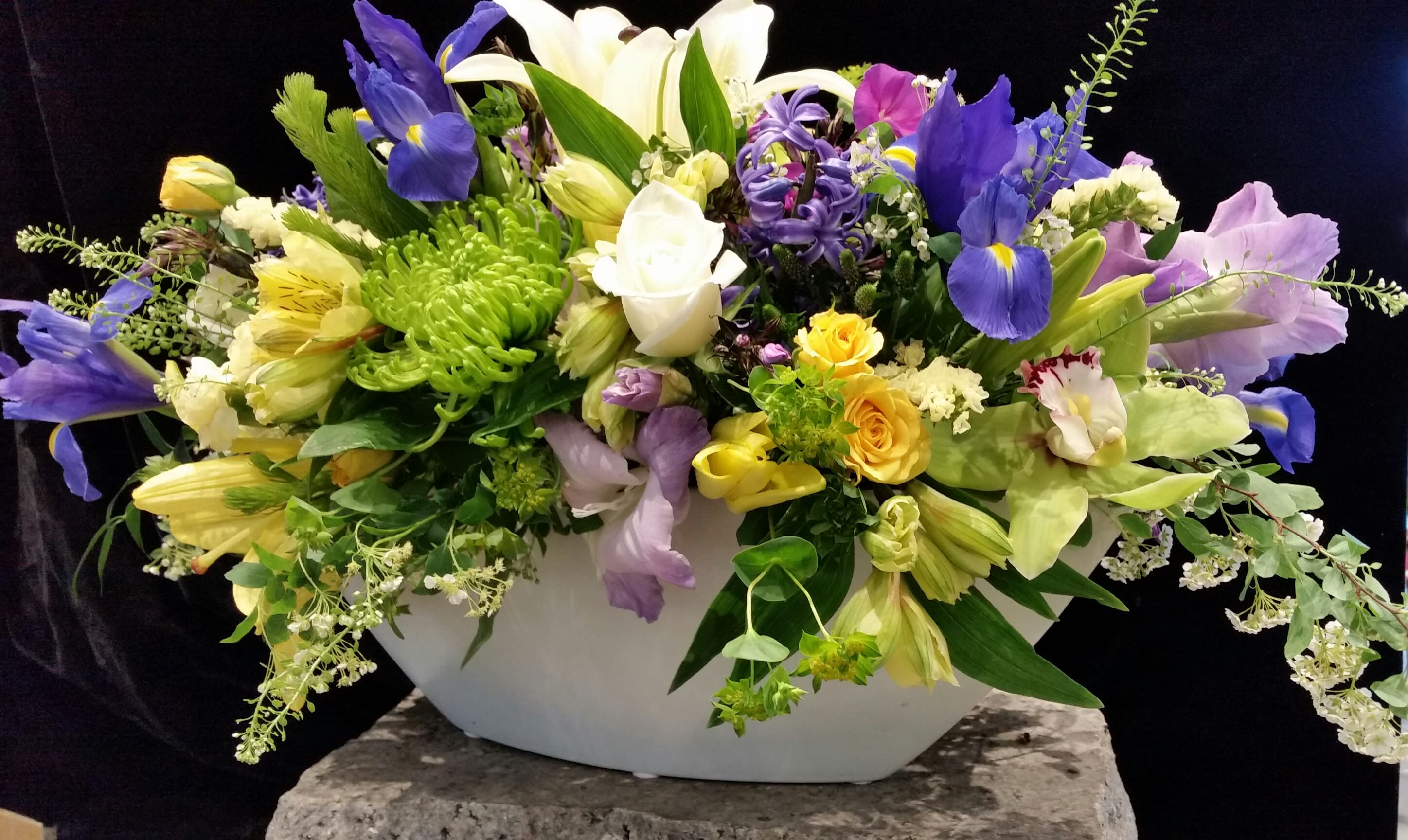 Festival - A beautiful, festive, Spring arrangement, perfect for your holiday table is exactly what our Spring Festival is.  Cut fresh from the best flower farms around the world, we've chosen orchids, iris, spray rose,  Gerbera daisies and textural greens and filler.  What a lovely centerpiece for you and your family to enjoy!