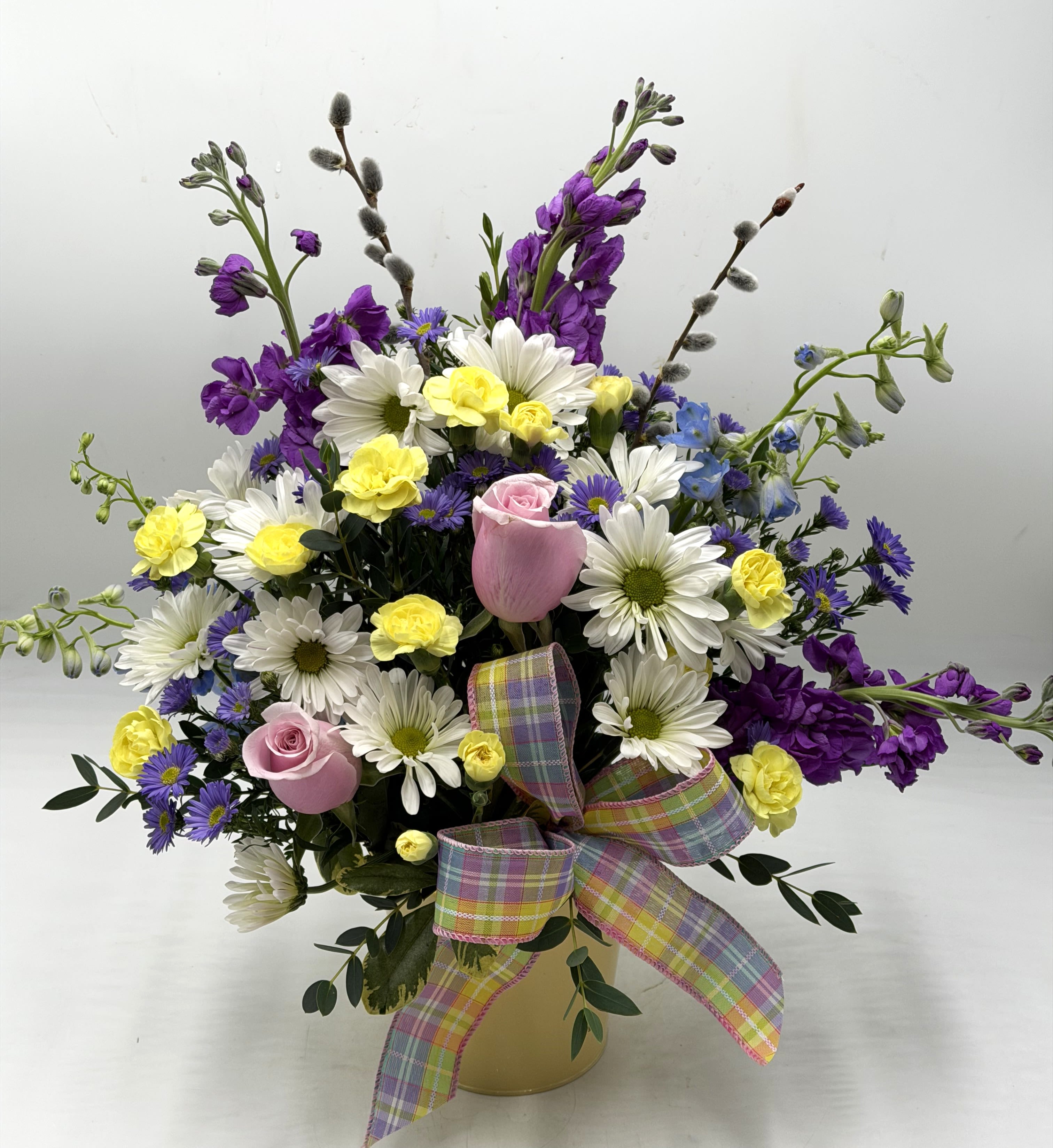 Spring Whisper - Soft, whimsical and full of springtime charm, this garden-style arrangement feels like a stroll down a blooming trail. Perfect arrangement to brighten someone's day and get them in the spring spirit!! ** CONTAINER COLOR WILL VARY **