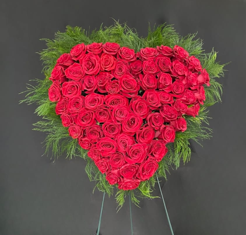 All Roses Solid Heart Wreath (Customizable) - A solid heart standing spray covered in beautiful roses. Colors and arrangement style can be customized to meet your needs. Arrangement shown using red roses. Other available colors include red, white, pink, yellow, purple, blue, green, orange or a mix. Heart is mounted on a 54" easel for easy display at a funeral service. Available in 18" (standard) and 24" (deluxe) sizes.
