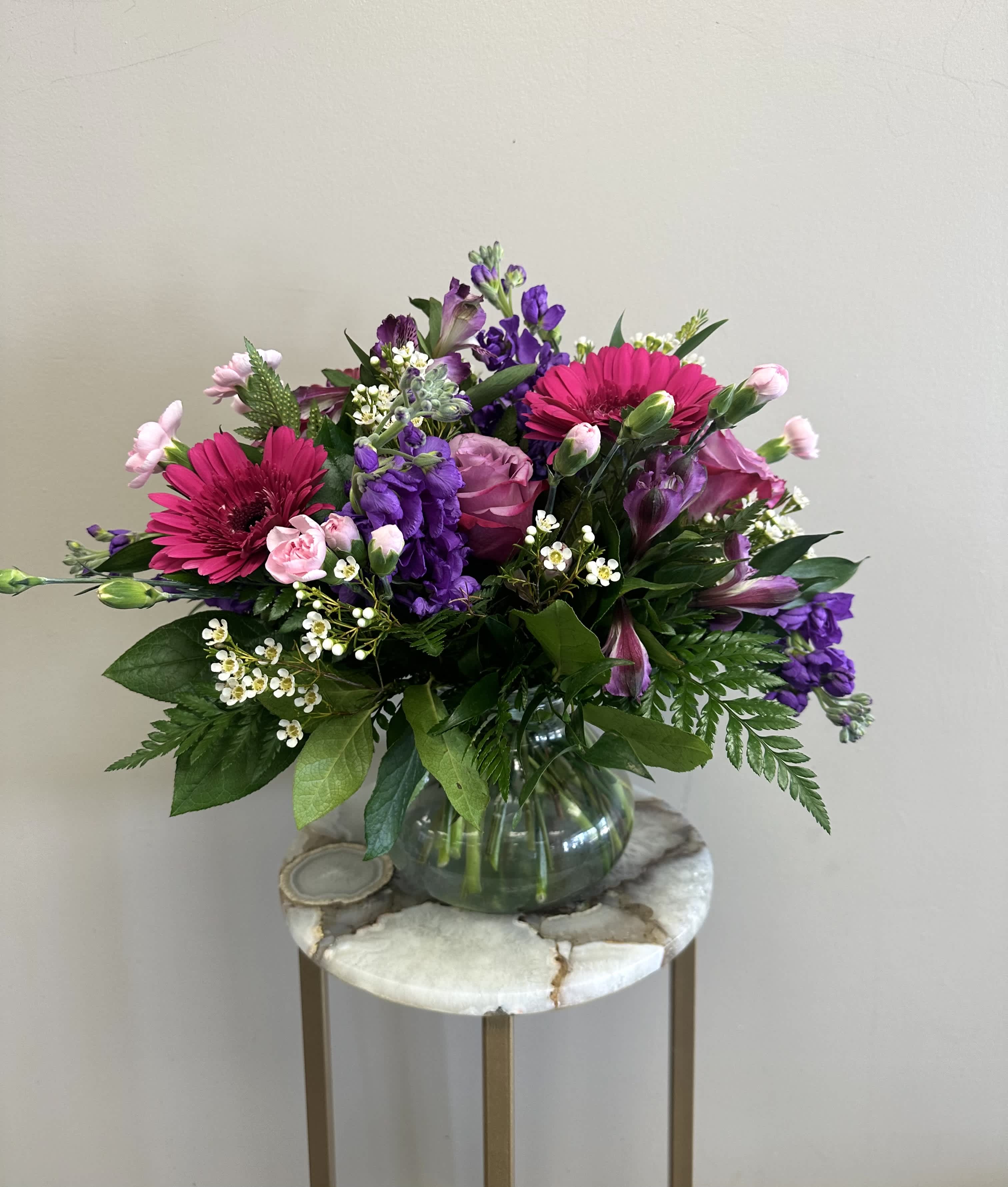 Garden Delight - A delightful pink and lavender mix of roses, alstroemeria, hot pink gerbera daisies, stock, queen annes lace and eucalyptus.  Approximately 6 in tall by 10 in wide.  