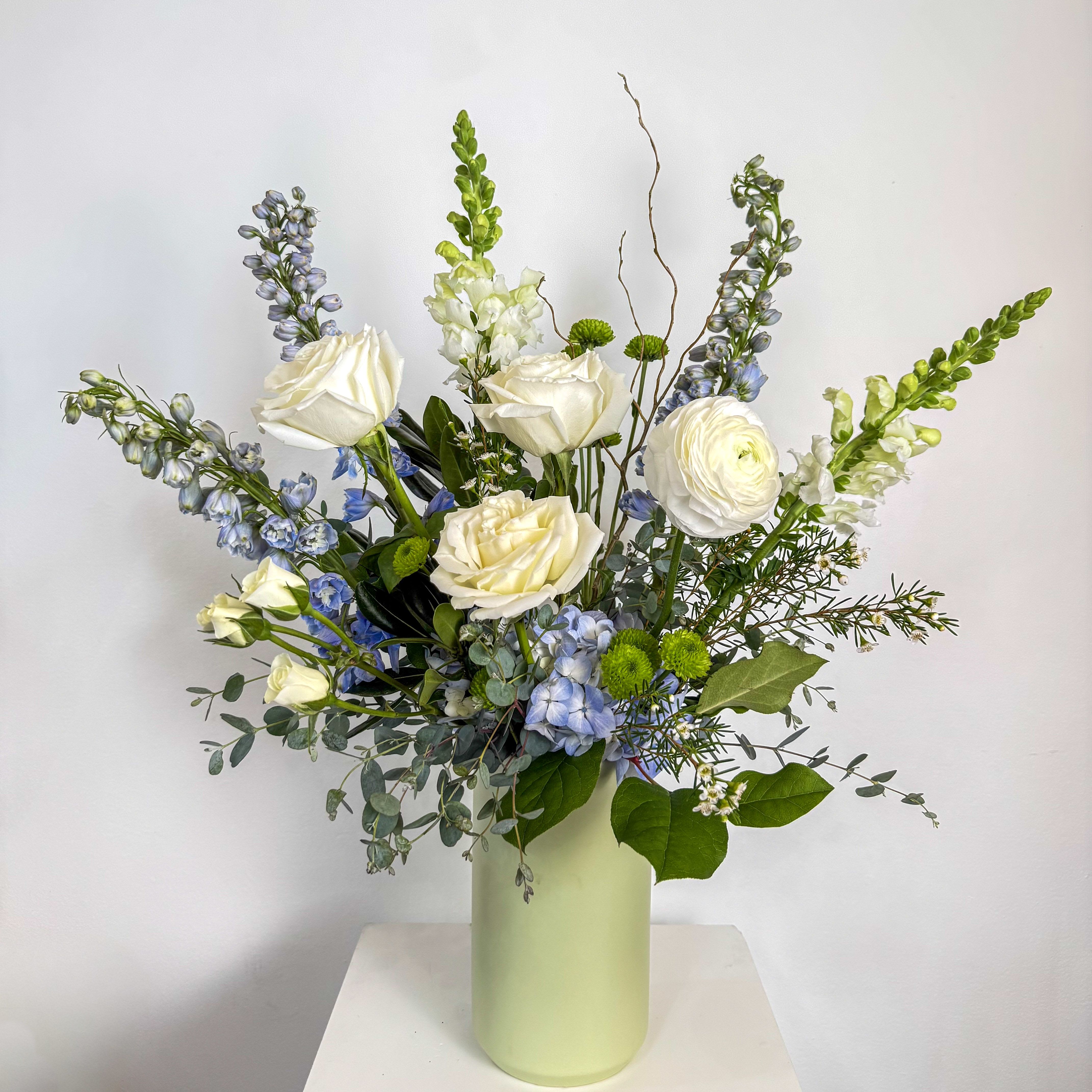 Blue Skies - A customer favorite, this arrangement contains a gorgeous mix of our freshest blue and white flowers.  Standard size measures approximately 10" x 14". 
