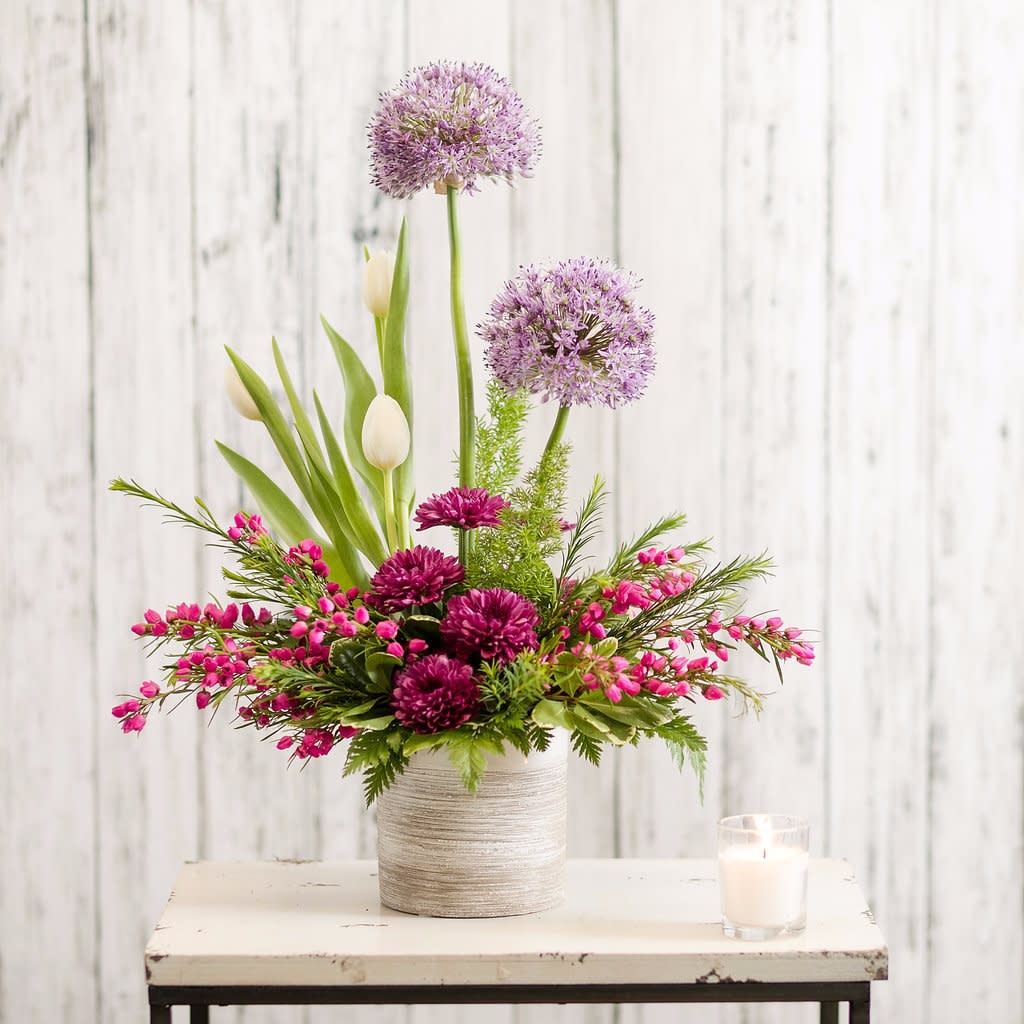 Lark - A textural mixture of springtime blooms includes heather, allium, tulips and mums in a classy ceramic container.  The perfect choice for a contemporary personality!