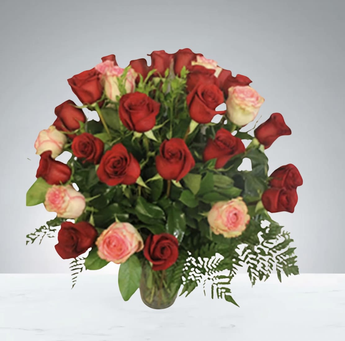 Red &amp; Pink Love by D'Lily's Flowers  - A beautiful arrangement of red and pink roses, accented with fresh greenery in a clear glass vase. Simple, elegant, and perfect for any occasion.