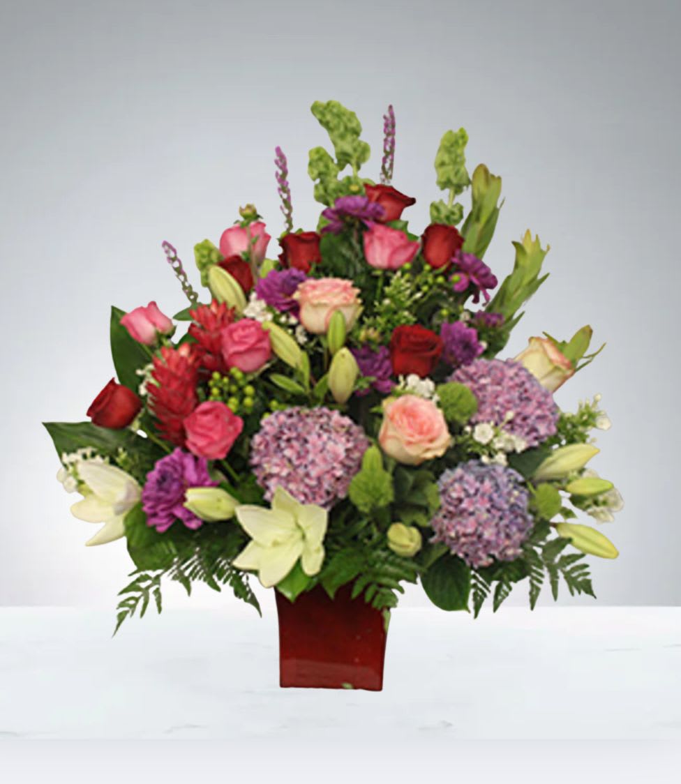 Melody  by D'Lily's Flowers  - Big arrangement with mixed colors and one face.