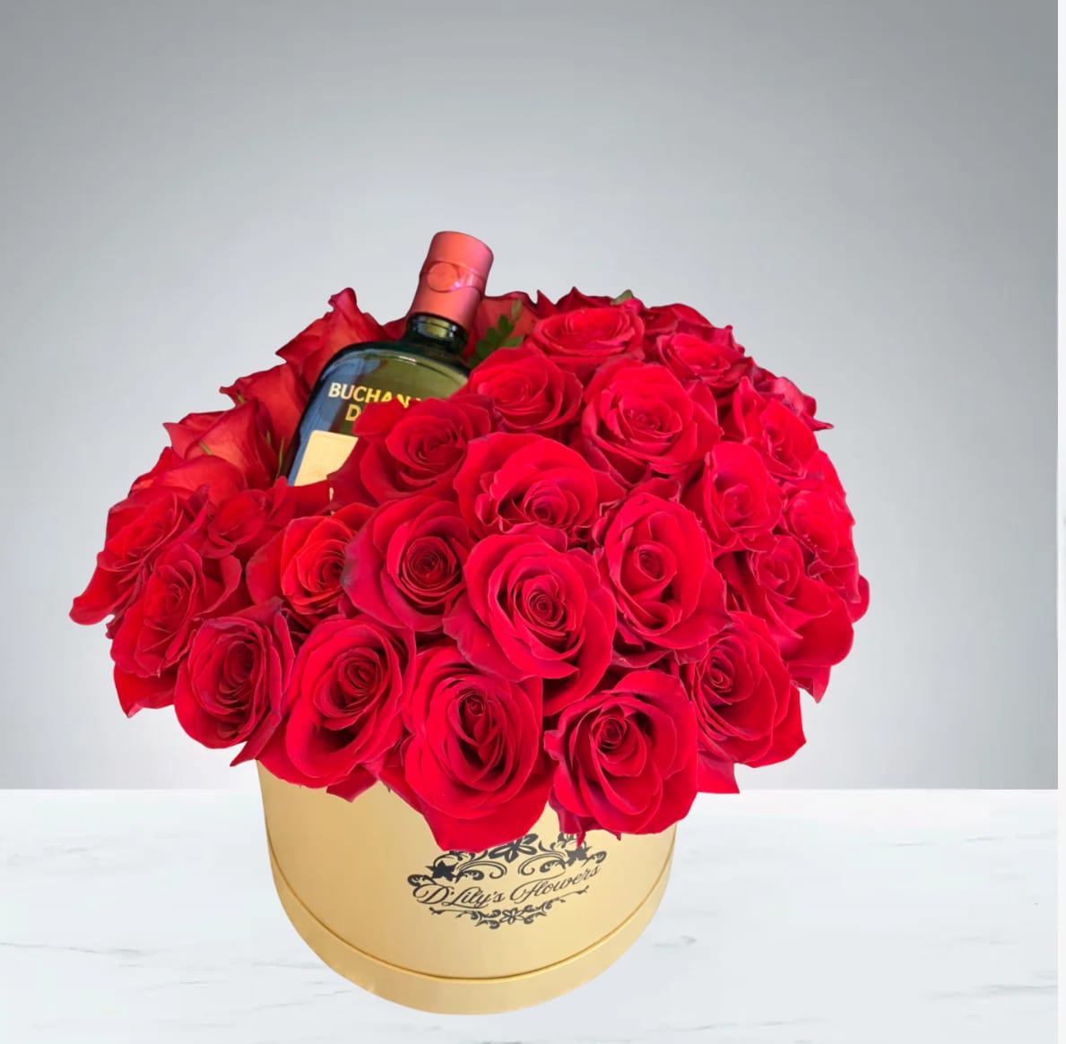 Red Celebration  by D'Lily's Flowers  - Celebrate with this beautiful red rose arrangement in a box! Disclaimer: Alcohol bottle is not included. Flowers may be substituted if needed.