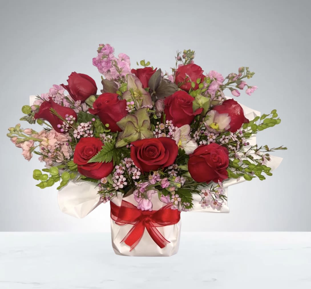 Madly in Love  by D'Lily's Flowers  - Surprise them with this stunning red rose arrangement a gesture that will keep them smiling all day long! Stunning red roses, stock, hellebores and pink waxflower