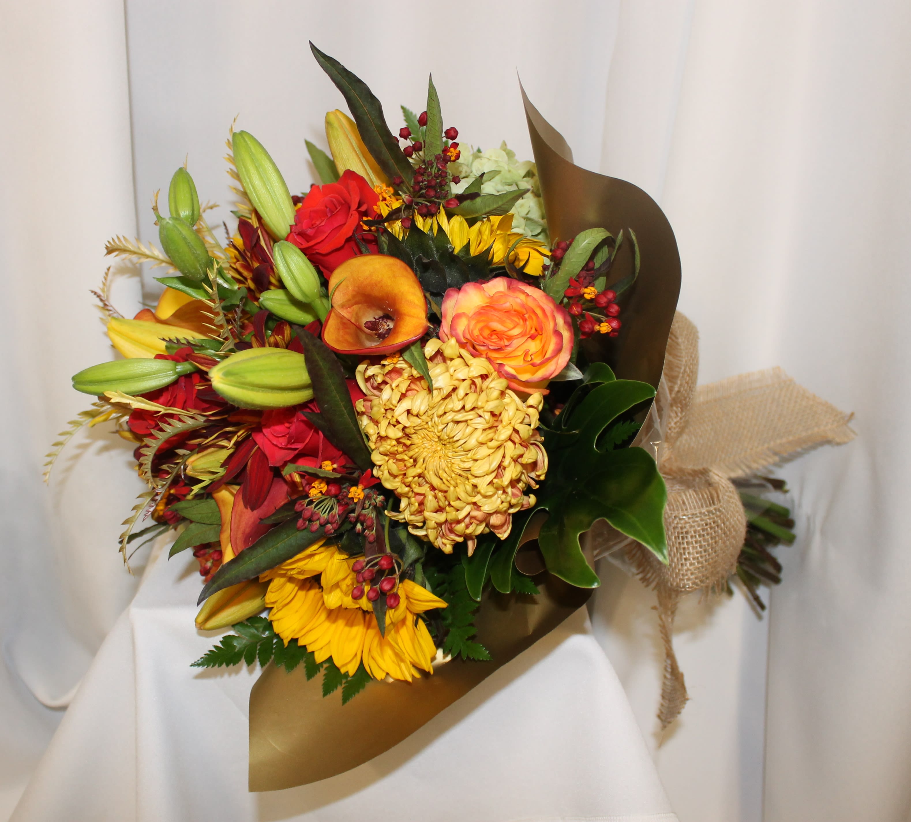 Harvest Time by D'Lily's Flowers - An Autumn look to this colorful hand-held bouquet. Disclaimer: Flowers may be substituted if needed to. 
