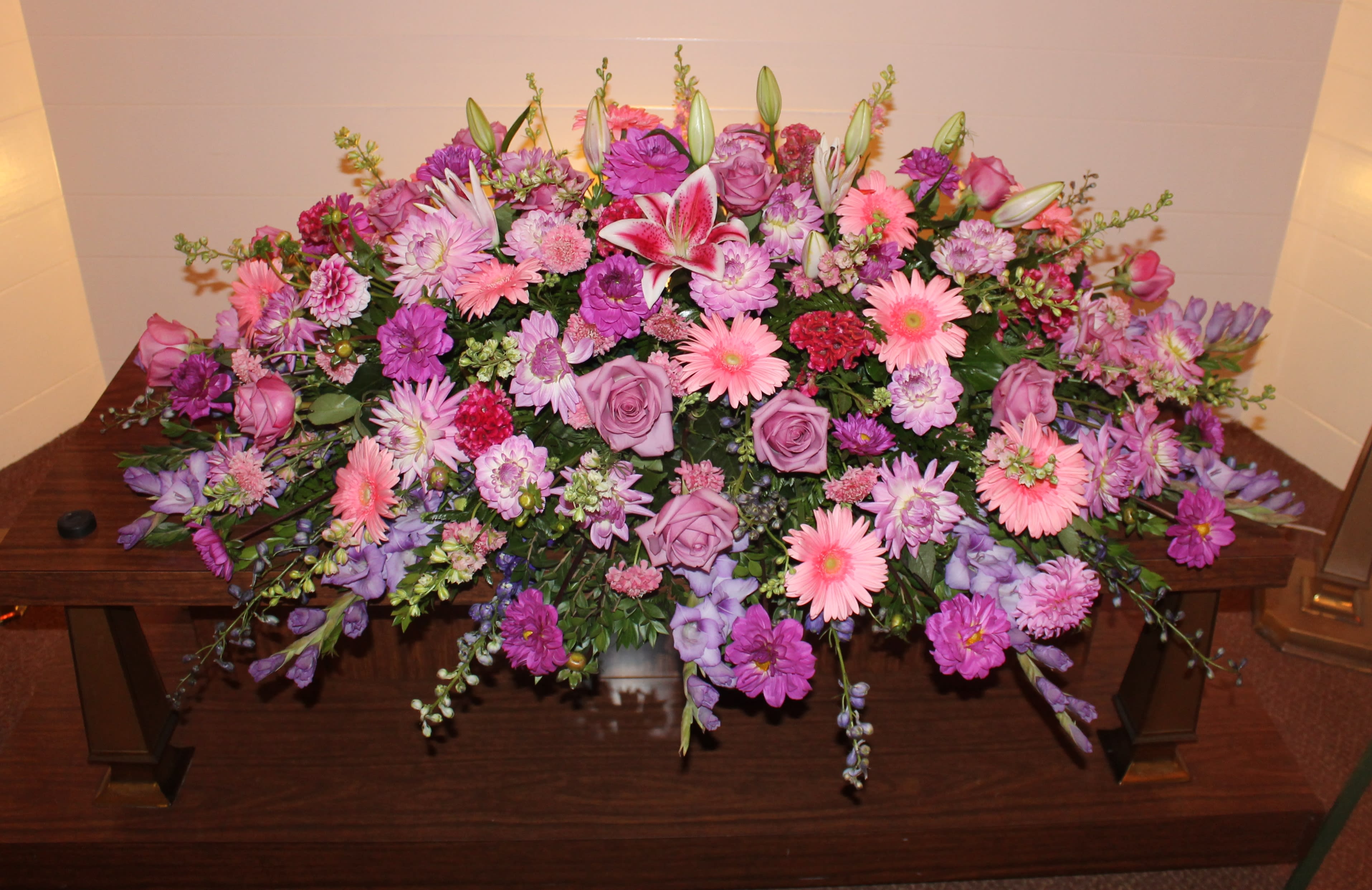 The Flowers of Love - A sweet display to this casket arrangement in lovely pinks and purples.