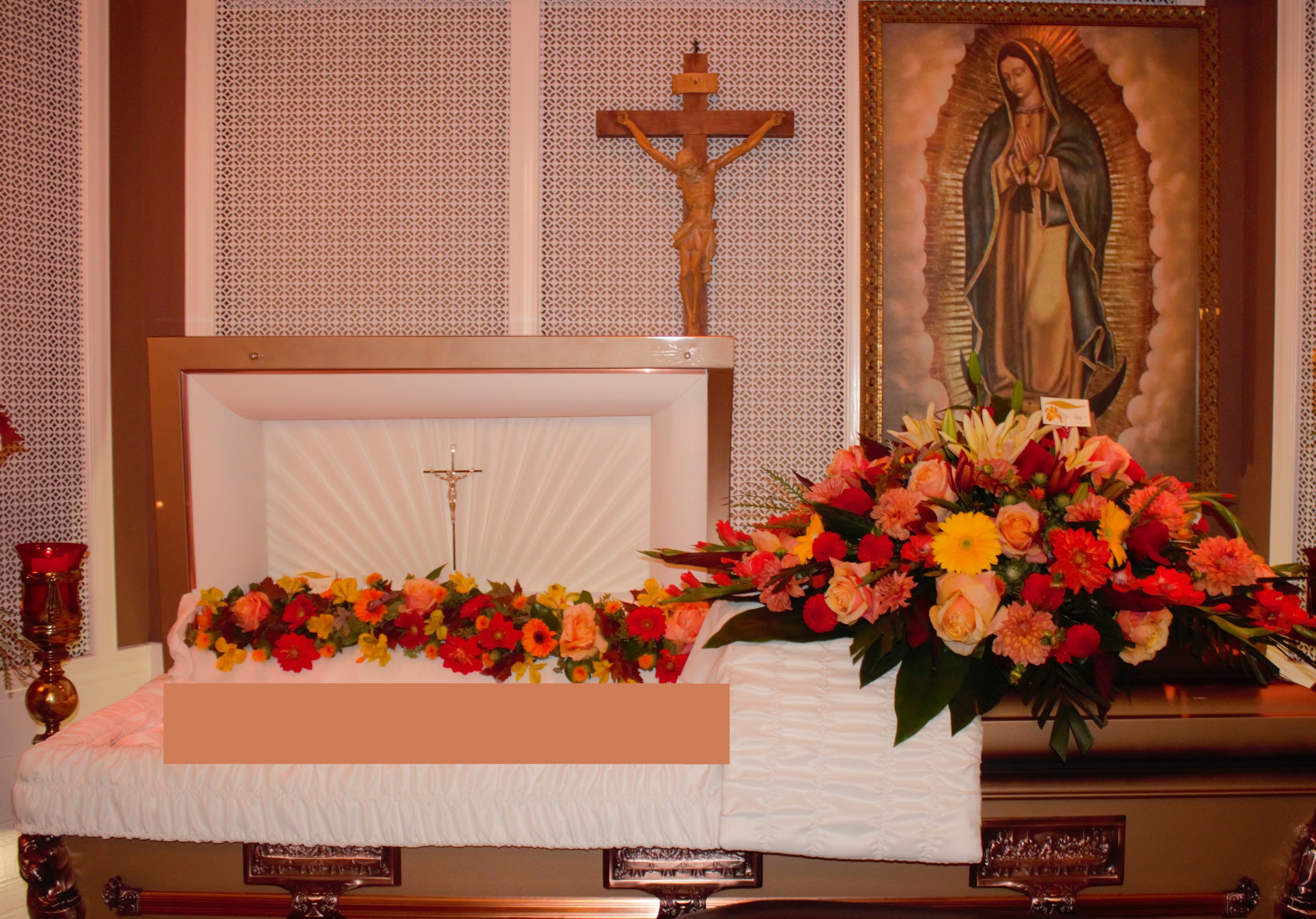 Lovely Orange - This couple includes the casket arrangement and garland in warm peach tones.