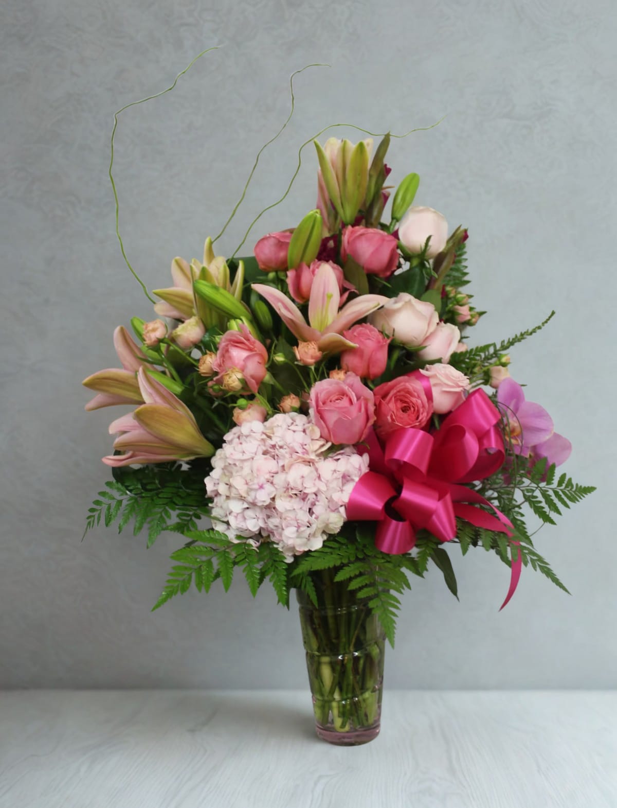 Beauty-Full  by D'Lily's Flowers  - This is a gorgeous flower arrangement in tones of pinks with some greenery in a clear glass vase.