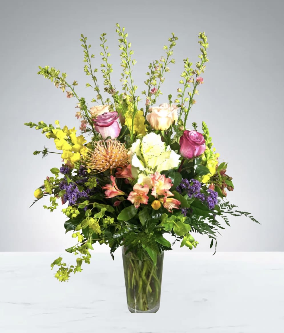 Spring Blossom  by D'Lily's Flowers  - This beautiful, grand arrangement hold a beautiful mixture of spring, bright, delightful colors and flowers. A grand way to make someone's day brighter.  Disclaimer: Flowers may be substituted if needed to.
