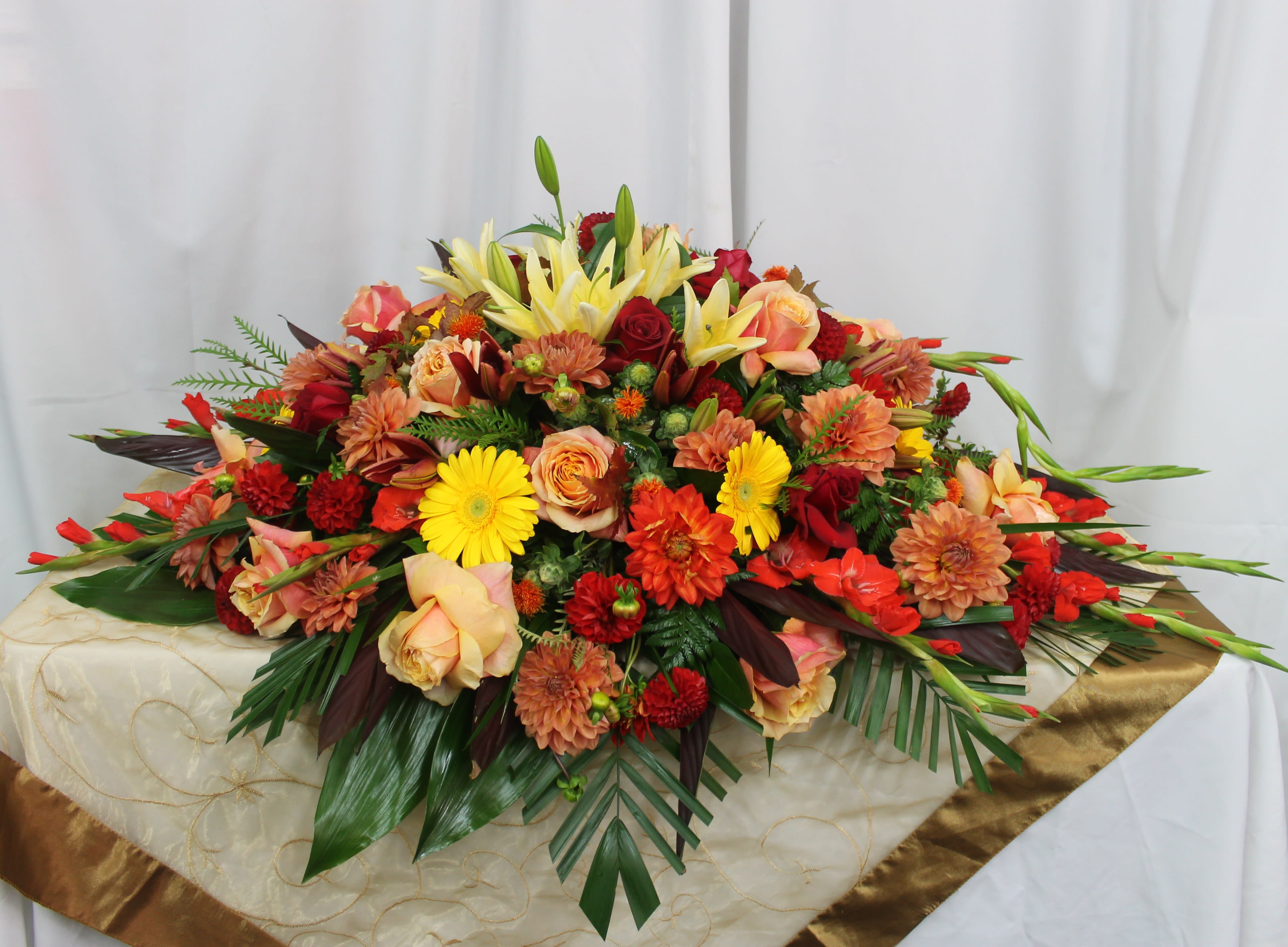 Warmth - This casket arrangement consists of warm colors for a subtle look.