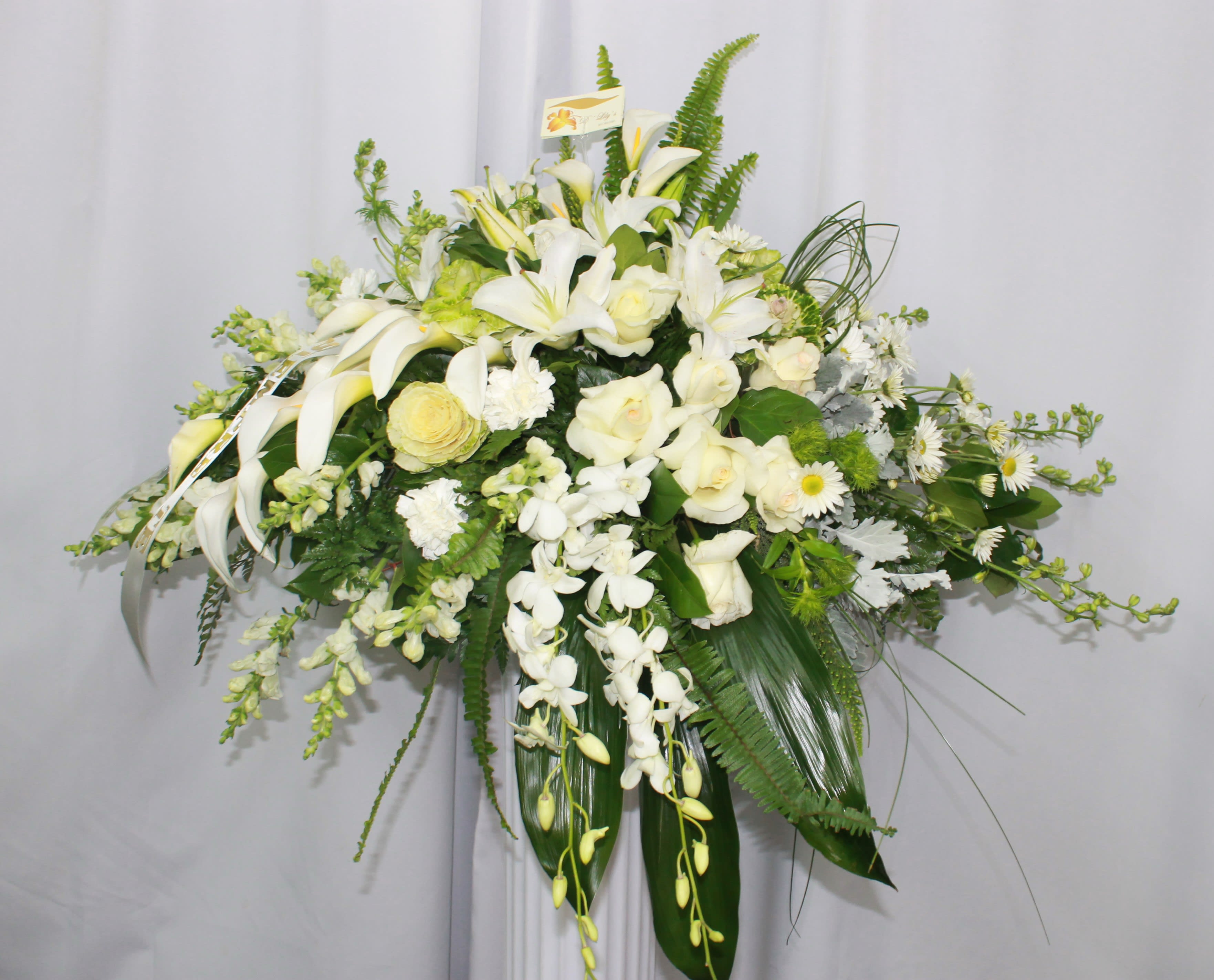 Pure Grace - Angelic casket arrangement in white tones with greens.