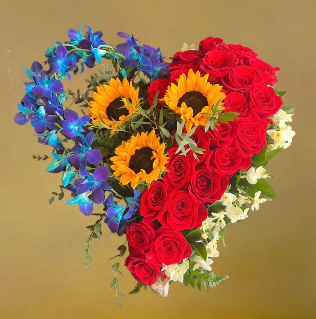 Radiant Orchid Heart by D'Lily's Flowers  - A heart-shaped arrangement with blue orchids, sunny sunflowers, and bold red roses—a vibrant mix of color and love. DISCLAIMER: Must pre-order at least a 5 days in advance. 