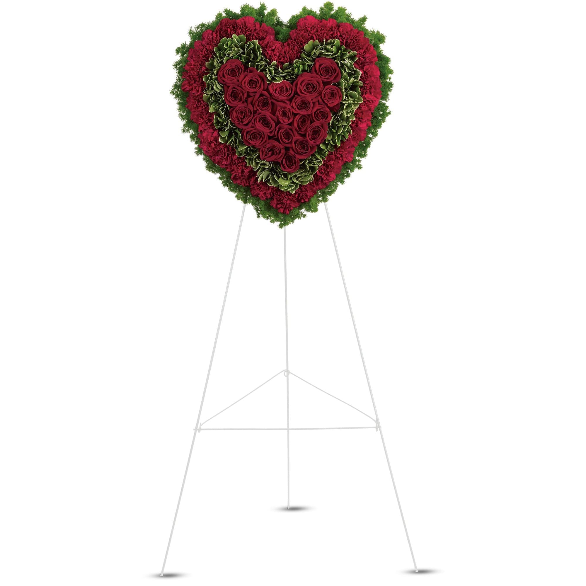 Heart-shaped standing floral arrangement of red roses and red and green blooms on a white easel