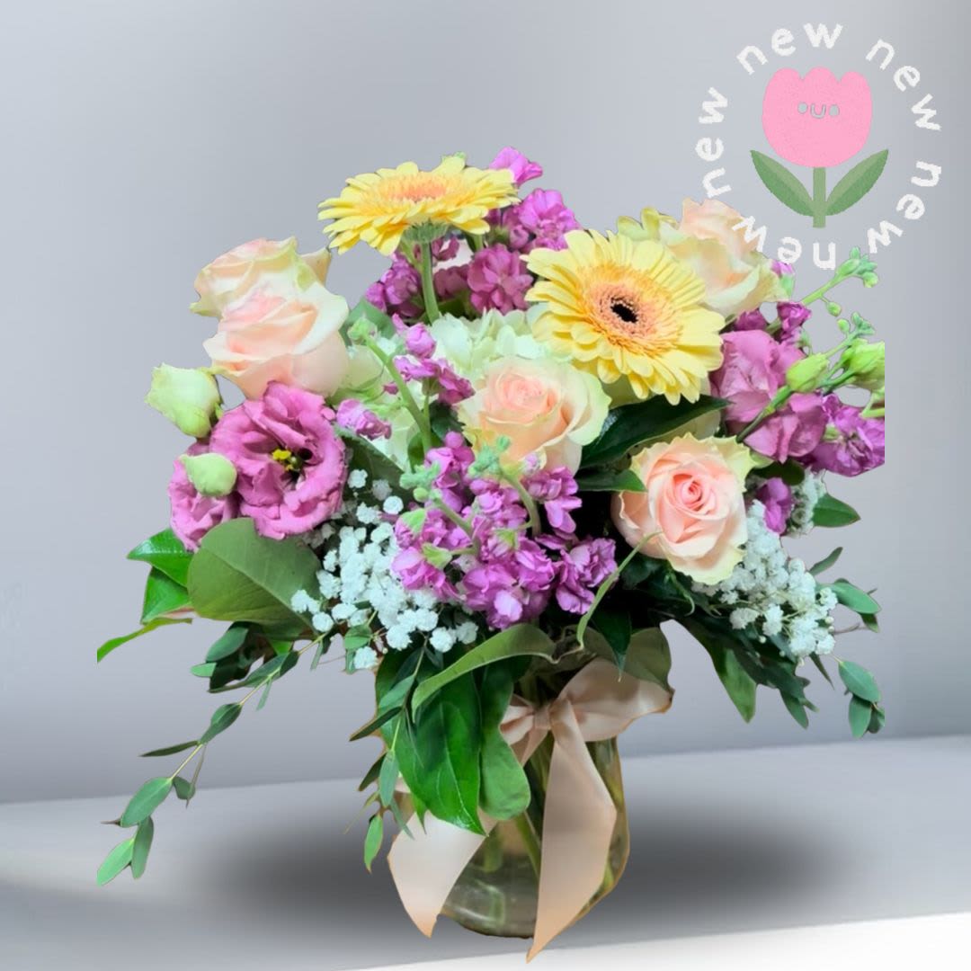 Blooming with Grace - You’re Blooming Gracefully is a soft, kind arrangement designed to feel both delicate and uplifting. Gentle pastel tones are complemented by a vibrant pop of fuchsia, creating a balanced blend of elegance and joy. Recipe: Gerbera Daises, Stock, Roses, babies Breath and Eucalyptus Season: All Year Round