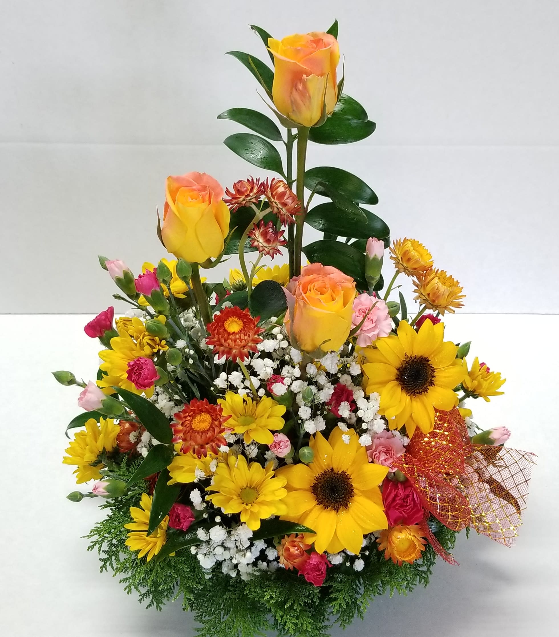 “Brighten Up Your Day!” Arrangement *If sunflowers are unavailable it will be substituted with more spring flowers. - A beautiful array of Designer Choice Sorbet Colored Roses with Sunflowers and an array of mixed spring flowers!