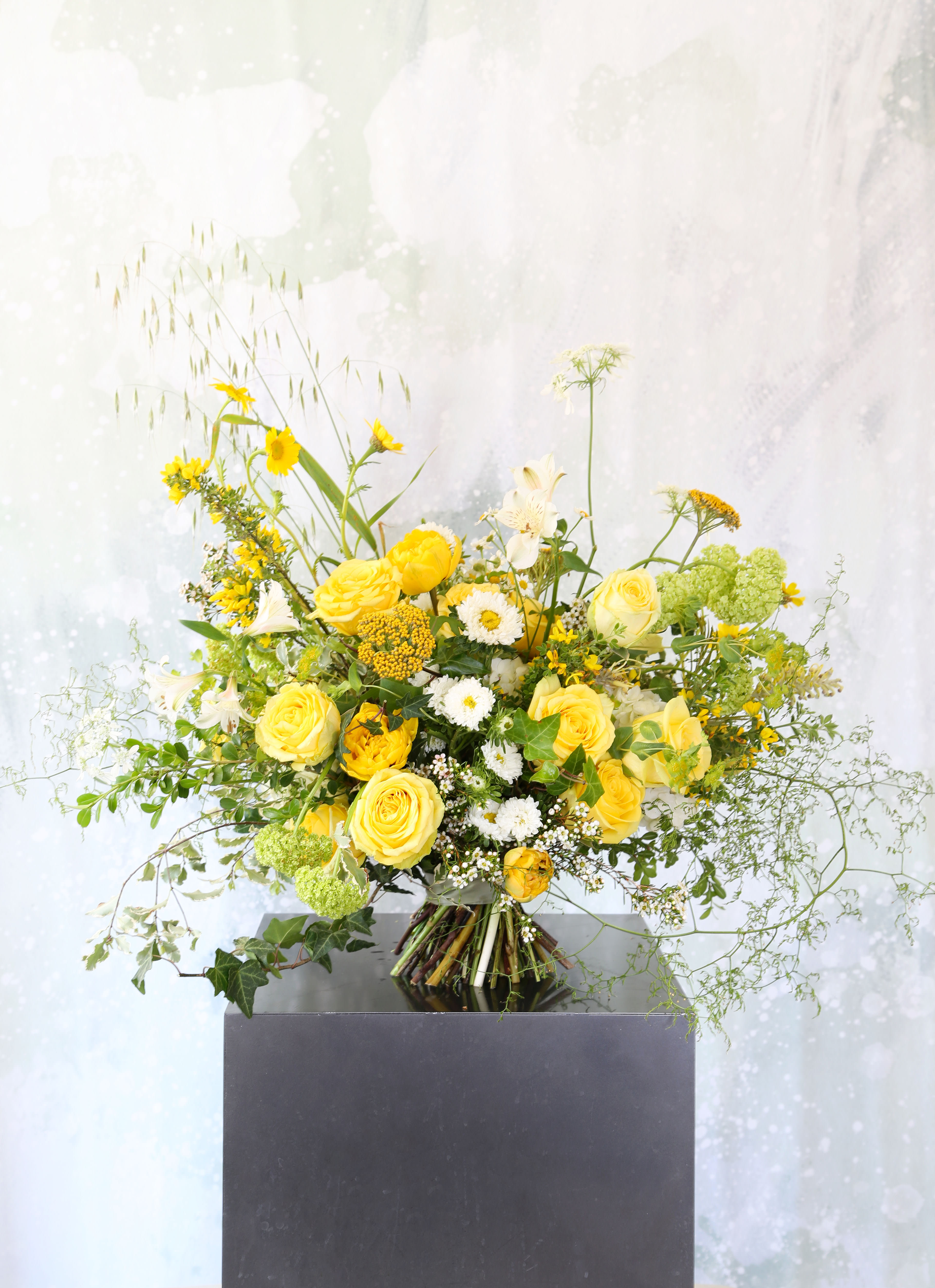 You are sunshine - This yellow and Green color combination handtie bouquet arrangement brings in a cheerful energy with yellow garden roses, hydrangea, tulip and seasonal bloom arrange in a 8" round glass vase with ribbon wrap . It comes with branded gift box and greeting card.