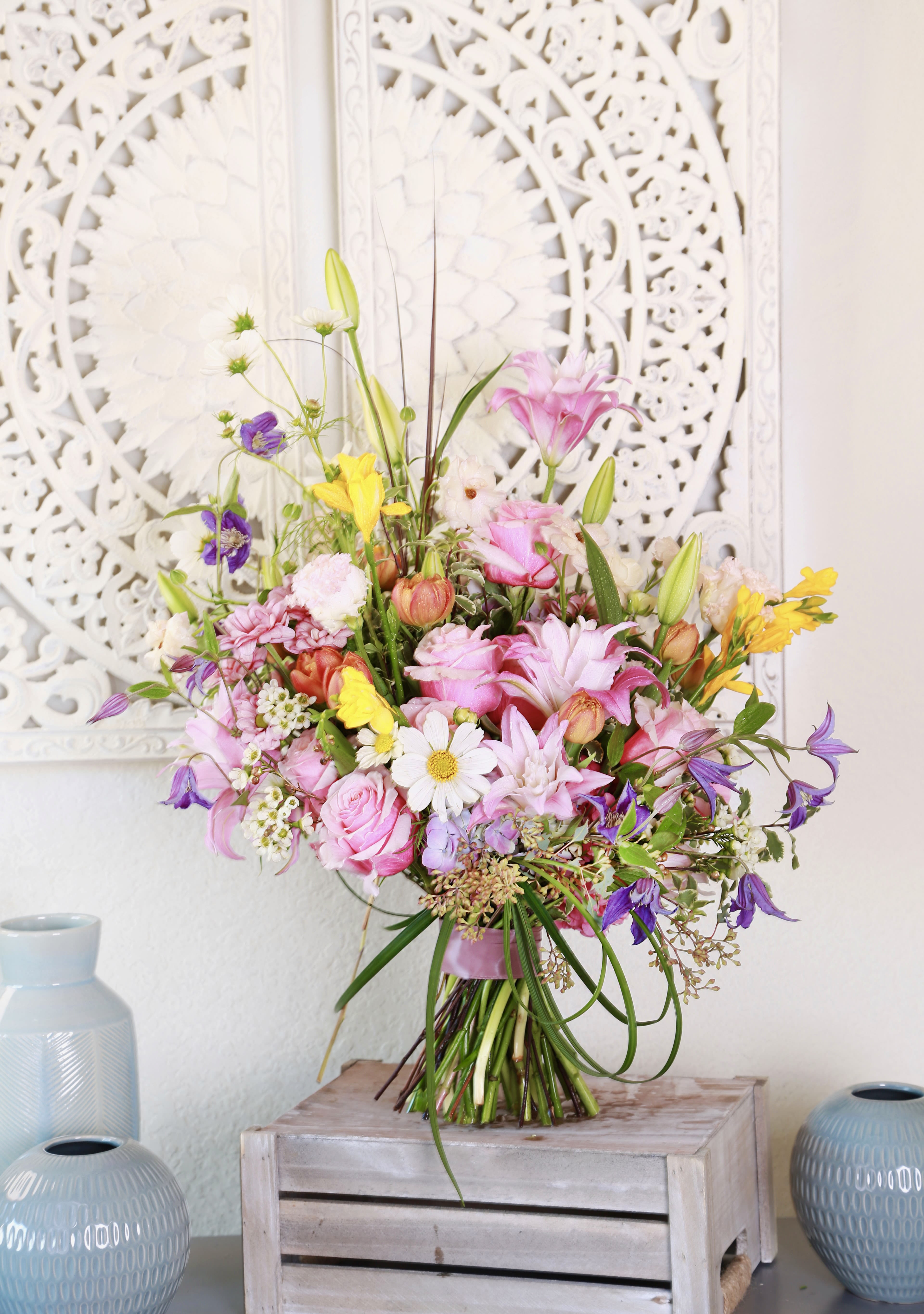 Blossom Bliss - Experience the enchanting allure of our "Blossom Bliss" arrangement, a celebration of vibrant colors and delicate textures. This stunning bouquet features a harmonious blend of seasonal blooms, including soft pink roses, cheerful daisies, and elegant lilies, all artfully arranged to create a visually striking centerpiece.   The mix of bright yellows, purples, and greens adds a refreshing touch, making it perfect for any occasion—from joyous celebrations to heartfelt gestures. Each flower is hand-selected for its freshness and quality, ensuring a long-lasting display that brings joy and warmth to any space.  Whether you’re looking to brighten someone's day or simply to indulge in the beauty of nature, "Blossom Bliss" captures the essence of springtime and the joy of blooms in full splendor.   We suggest this arrangement in Tall vase, and it will deliver with gift box with gift card as pic shown