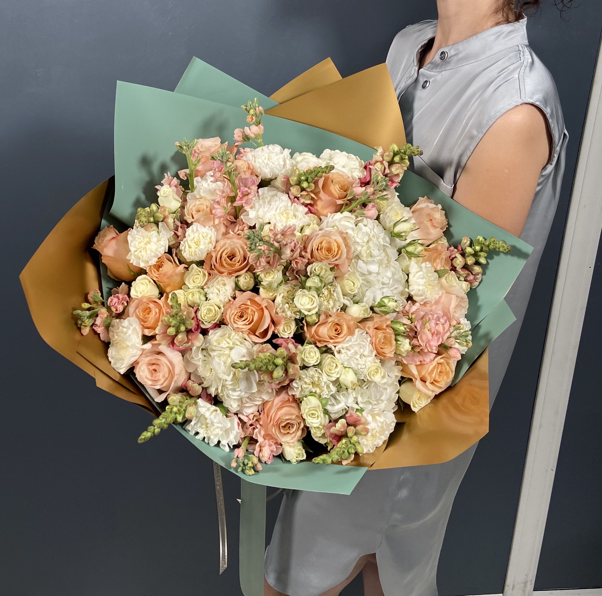 Vanilla Bloom P - This delightful bouquet features peach roses, white hydrangeas, spray roses, and pink snapdragons, creating a soft, romantic arrangement.  PREMIUM size is shown in the picture.