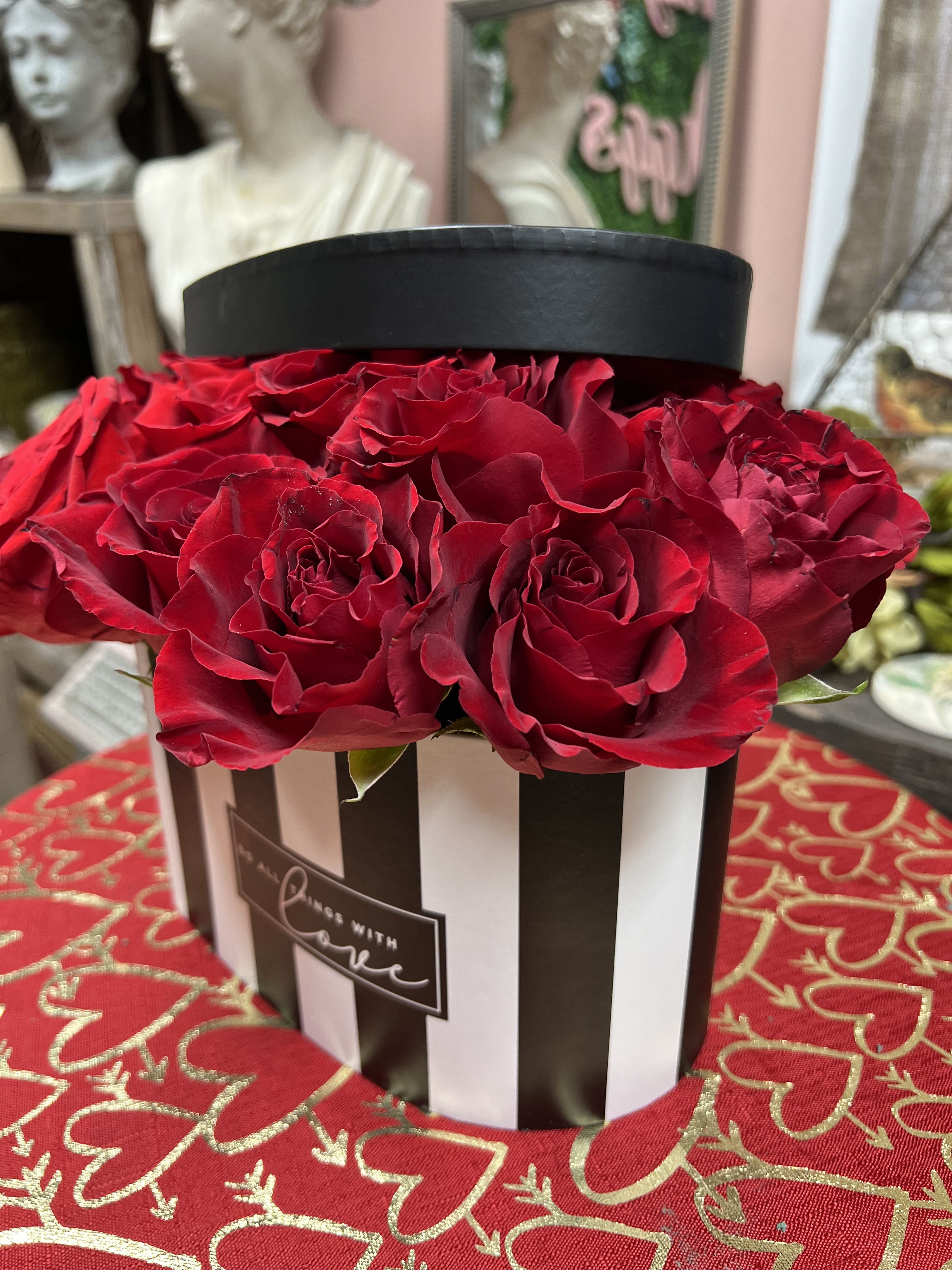 LOVE IN BLACK AND WHITE - Heart Shaped Black and White Stipped Box with lid  Arrangement. Consist of 24 Large Bloom Premium Roses Available in 4 rose color options (Red, White, Pink or Lavender) Please specify desired rose color in notes to florist.  Roses placed in wet foam with food preservative (to extend life of flowers)  also available in 12 rose count