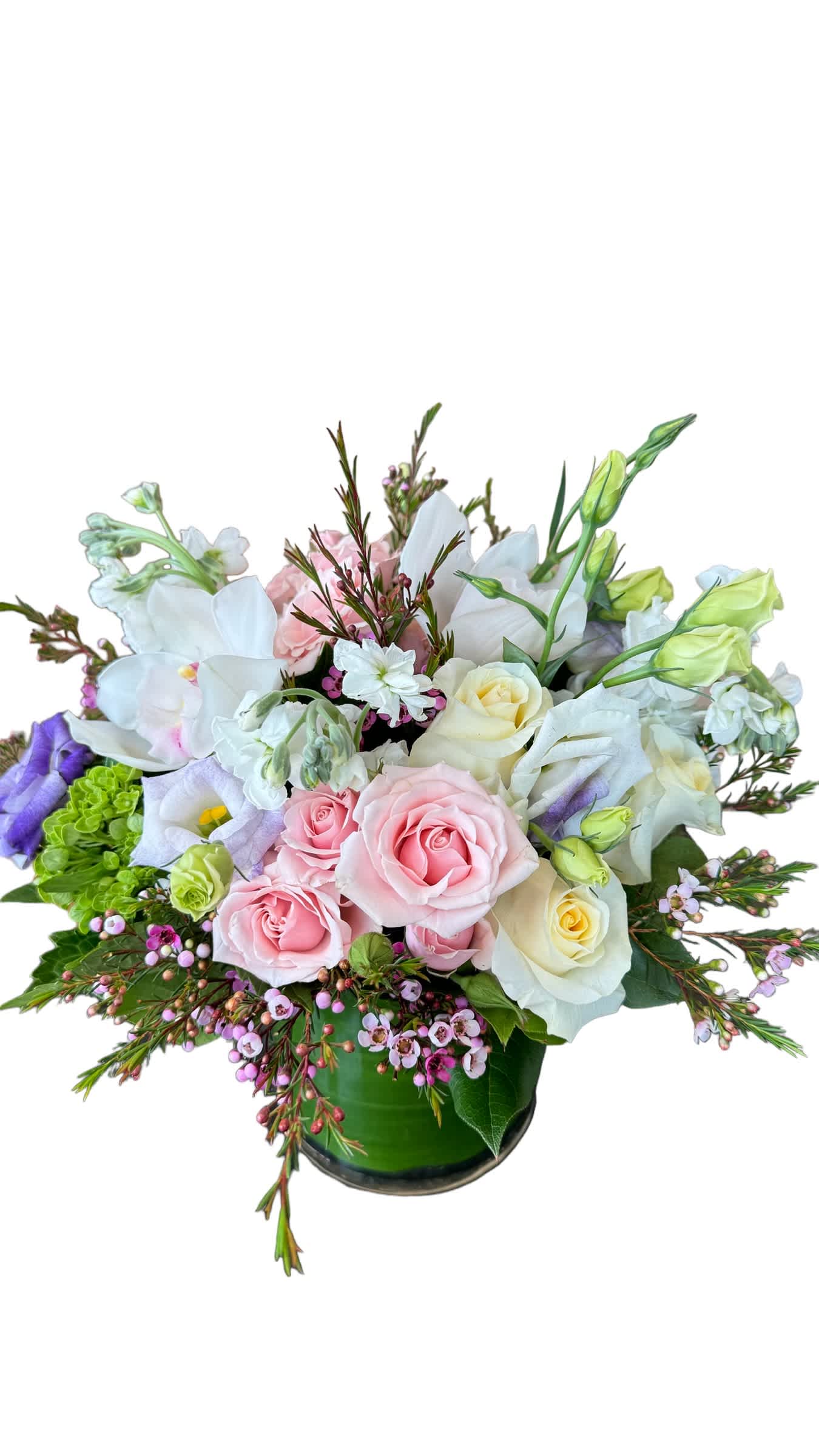 Elegant Spring Centerpiece  - Green hydrangea, purple lisianthus, light pink spray roses, white roses, white cymbidium orchid and wax flower designed in a round glass vase. 