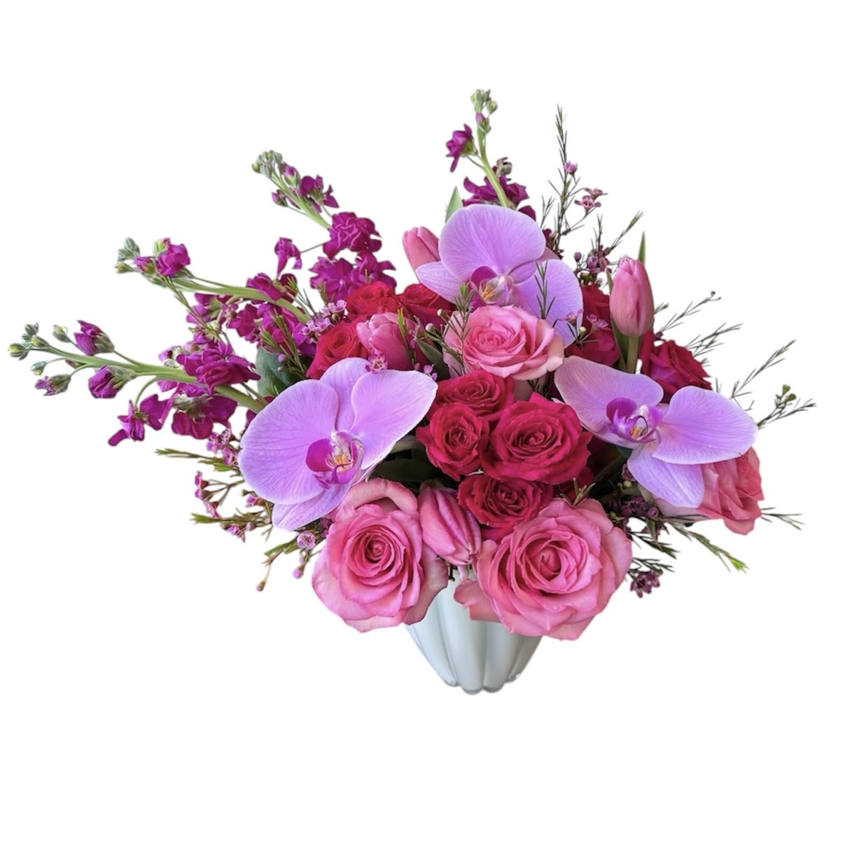 Love Story - Pink roses, purple orchids, purple stock, spray roses, tulips and wax flower designed in a glass vase. As shown in photo.