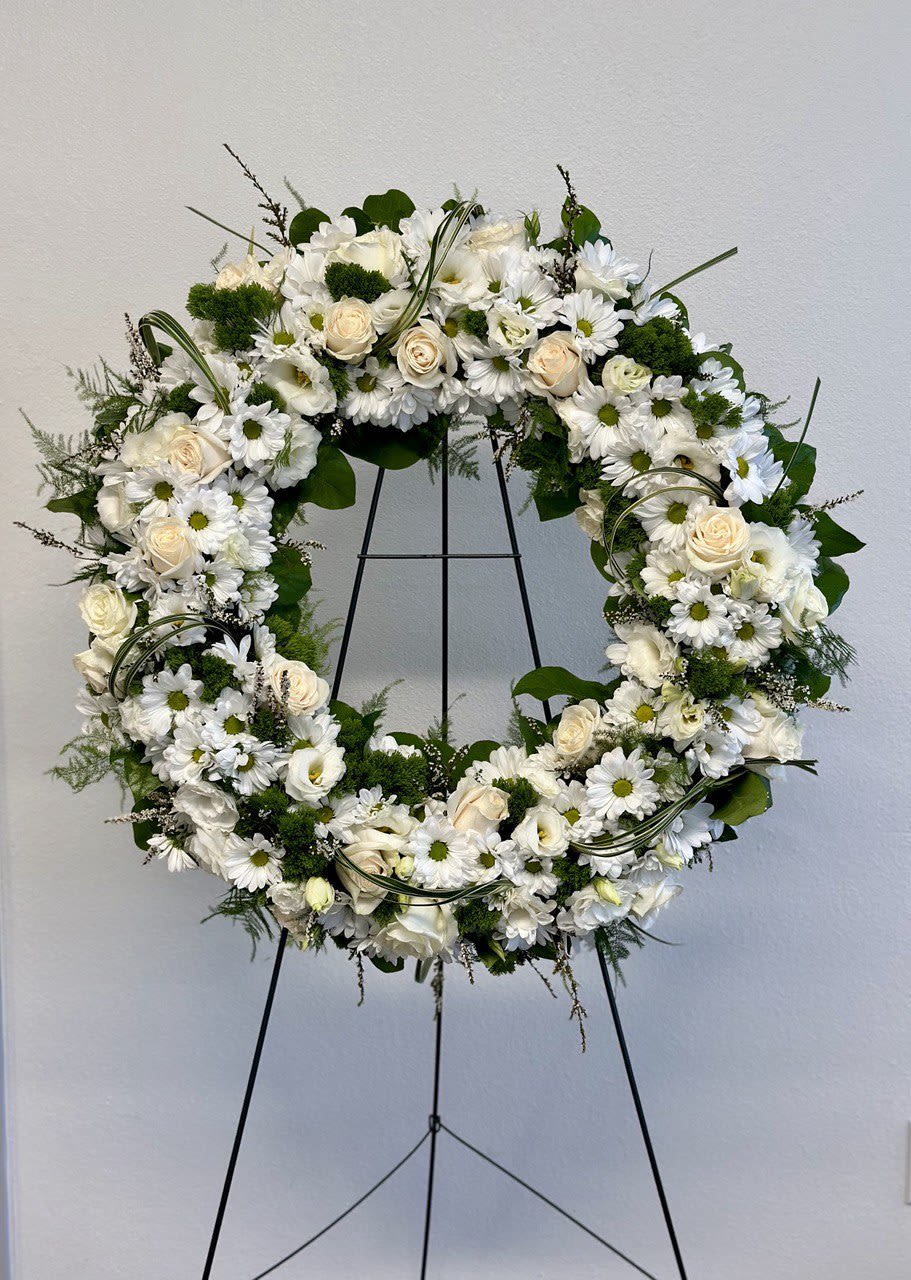 Lasting Serenity - A beautiful white and green tribute wreath that calms, this easel arrangement celebrates a full life and a peaceful passing.  The size of the foam is 20" and the height of the easel is 60".