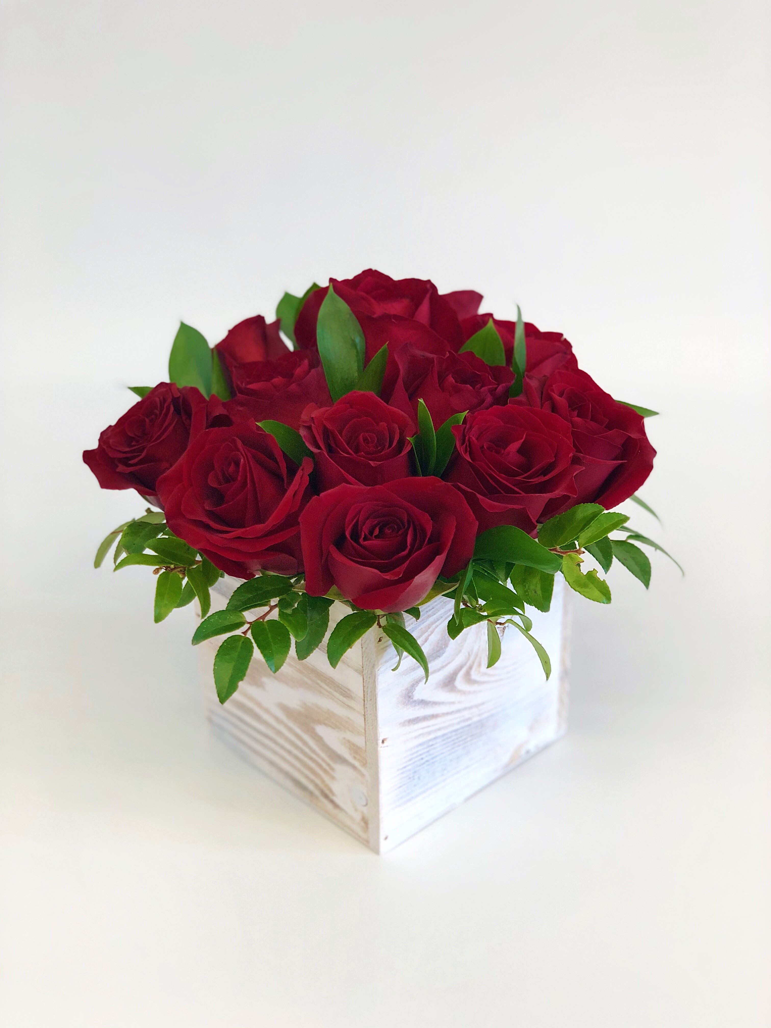 Red roses arranged in a white wooden box