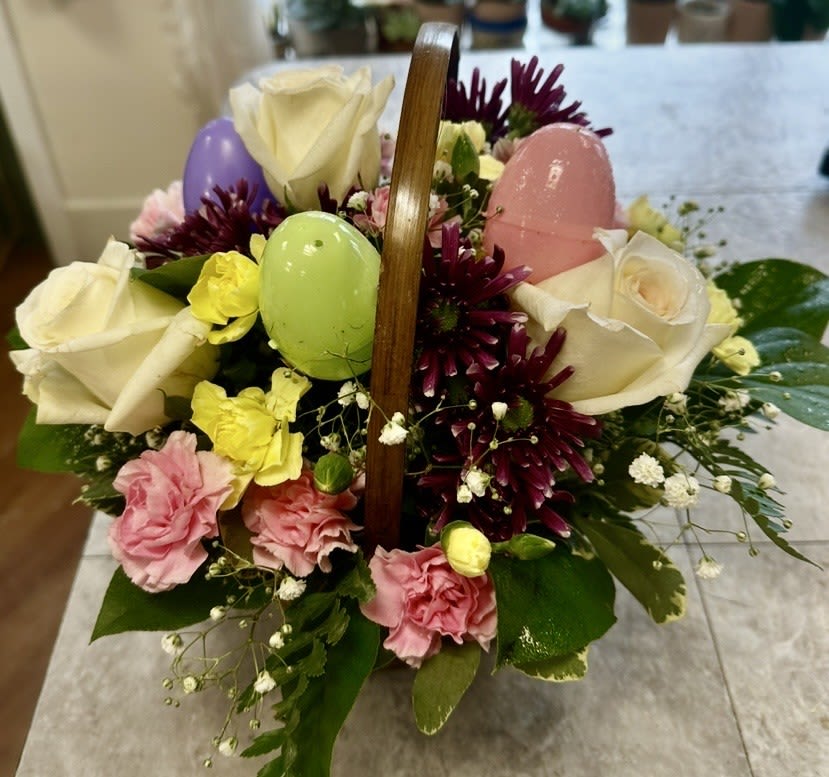 SPRING SURPRISE EASTER BASKET - CUTE EASTER BASKET OF PLASTIC EGGS, ROSES, MUMS, CARNATIONS AND BABY'S BREATH WITH GREENS. A HAPPY ADDITION TO YOUR HOME THIS EASTER