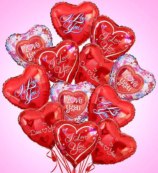 Bundle of red heart-shaped I Love You balloons against a pink background