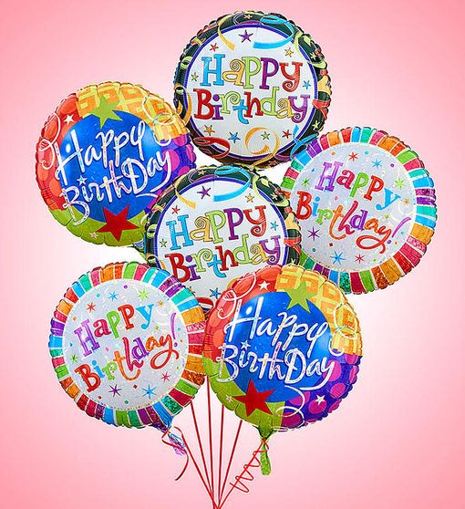 Cluster of colorful birthday balloons against a pink background