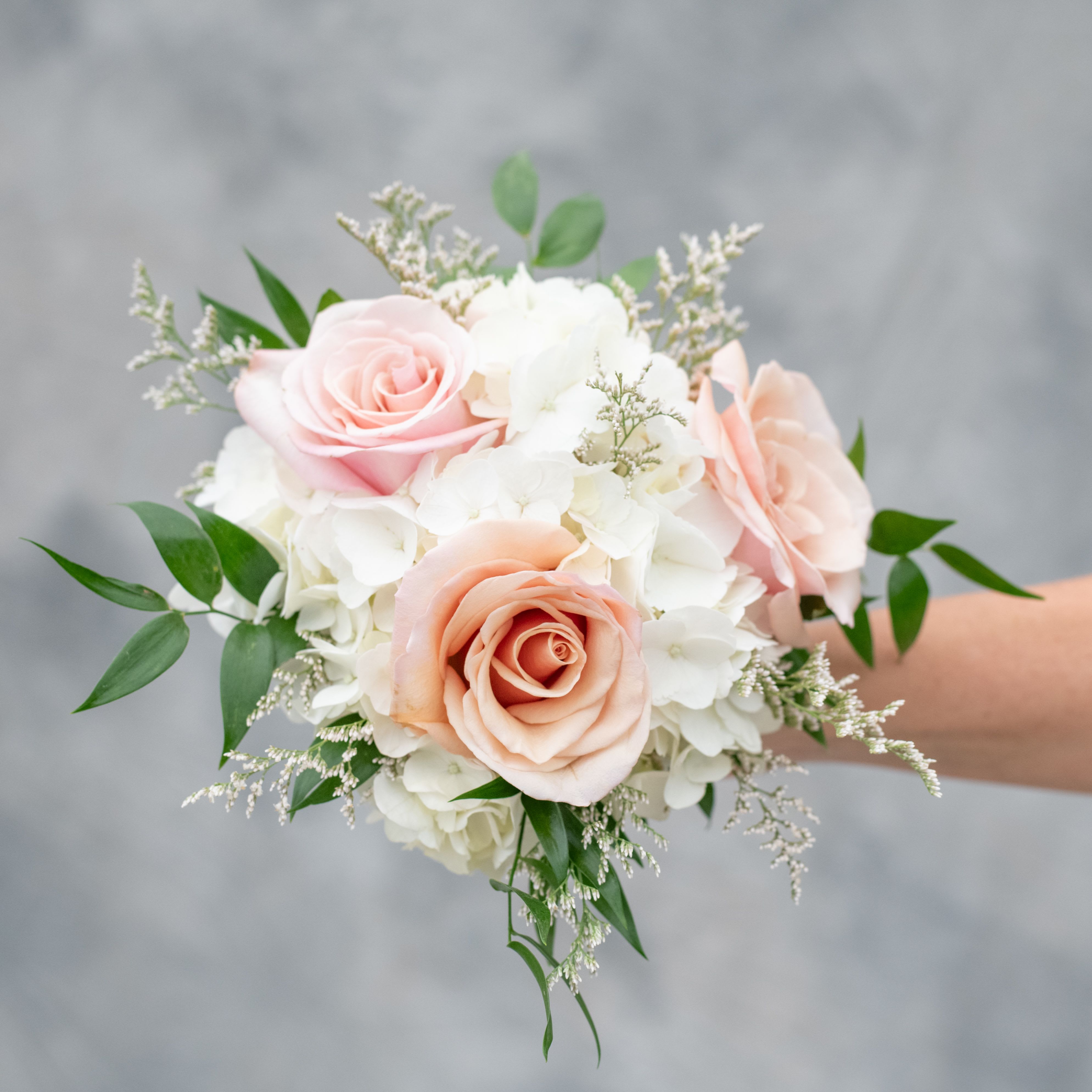 Classic Hand Held Prom Bouquet - Let our wedding designer choose a lovely assortment of hydrangea,  roses and either limonium or baby's breath using colors to perfectly complement the unique color and style of your gown. Your bouquet will be finished with soft greenery and will be tied with a coordinating satin ribbon chosen from over 40 exclusive colors