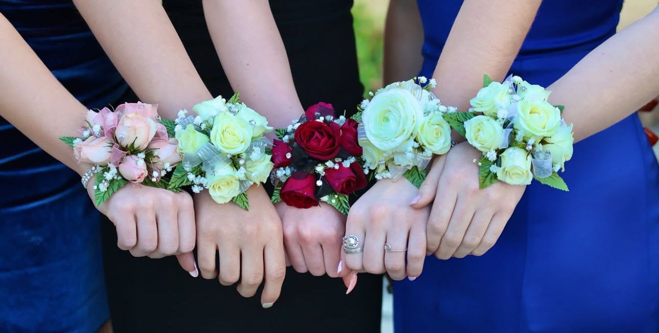 HOCO/PROM Wrist Corsage - Homecoming &amp; Prom Wrist Corsages Add the perfect finishing touch to your look with a stunning wrist corsage designed for style and comfort. Each corsage is crafted with 3 fresh roses or florals and greenery, and can be customized to match any boutonniere or bouquet for a coordinated ensemble. From classic roses to modern designs, with your choice of ribbon color, our corsages are made to complement your outfit and make your special night unforgettable.  Choice of Crystal, Pearl or Glitter Band. Please list Band Choice and Color in the notes. 
