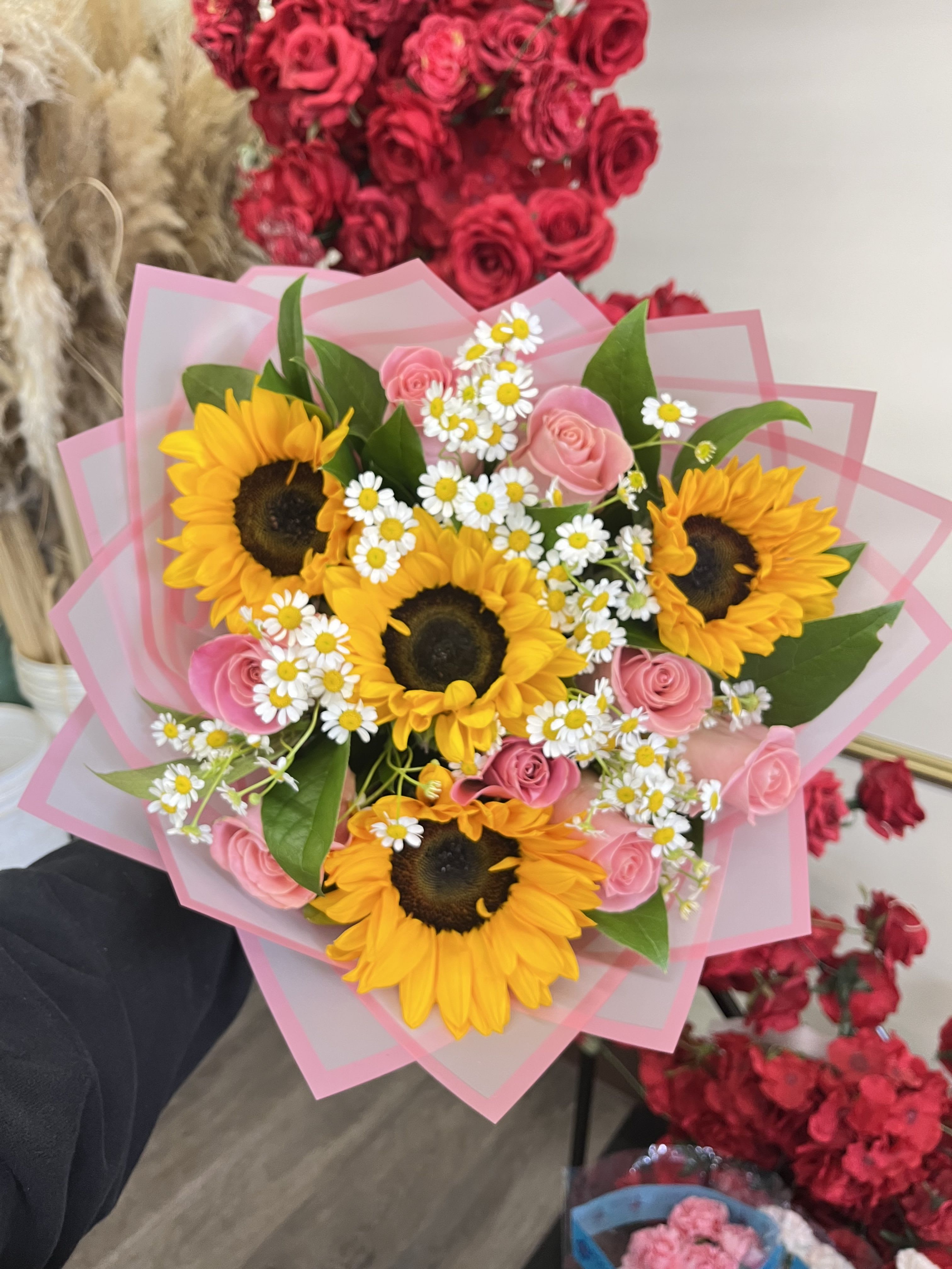 Pink Rose Sunflower Mix - Brighten any day with this cheerful arrangement featuring sunflowers, pink roses, chamomile and greenery, wrapped fir the perfect finishing touch. 