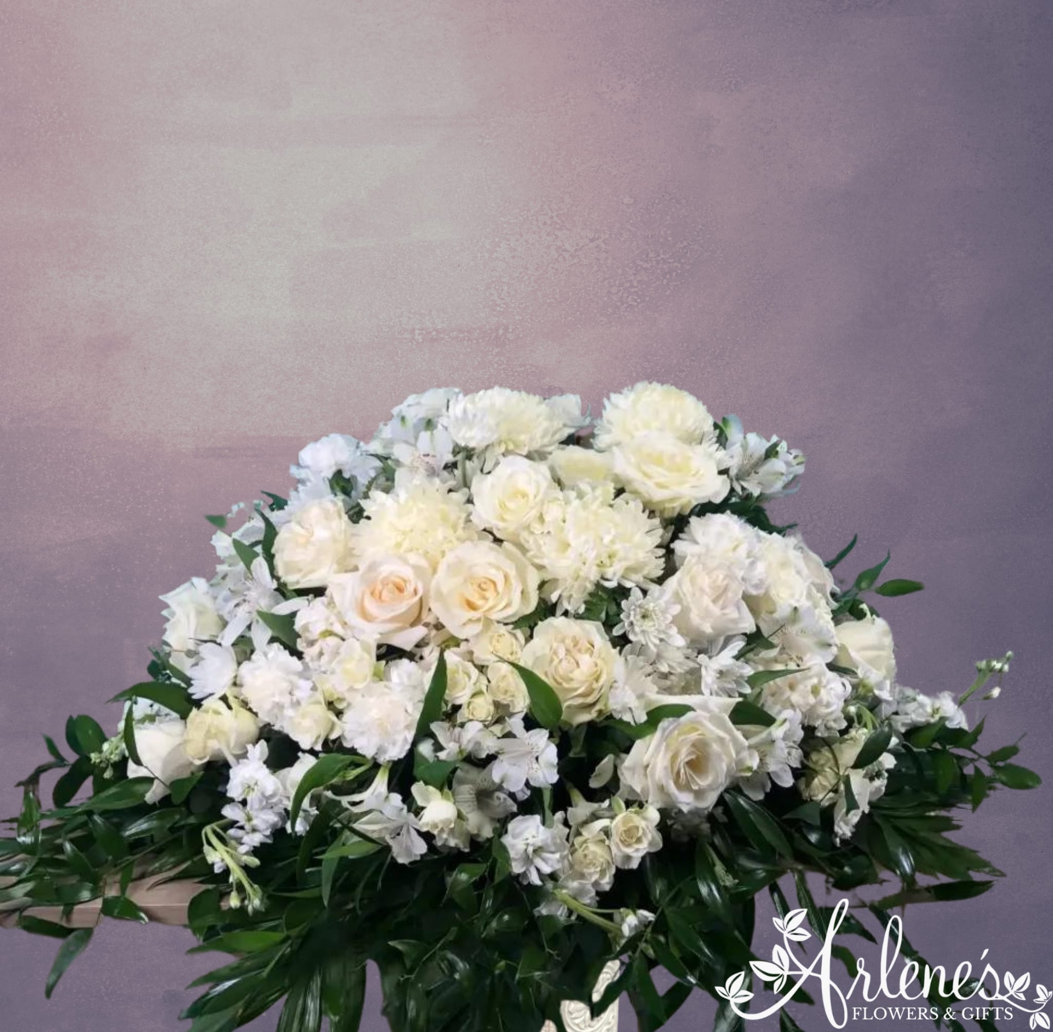 Soft Cloud Casket Spray - Designer's dreamy mix of cream and white flowers to make a soft, rounded cloud for your loved one's casket. Like a gentle rain, the greenery will just barely drape down from underneath and around the sides.