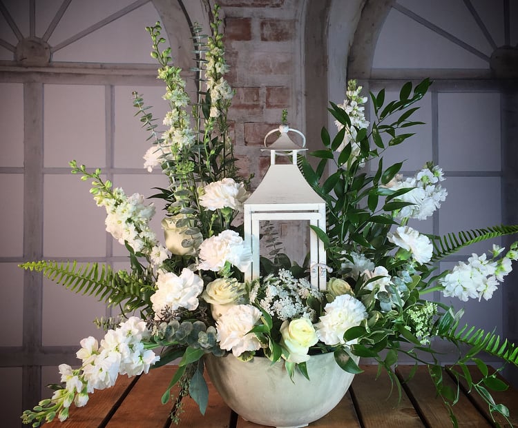 Guiding Light - To remember the passing of someone who helped light your way. This is a mixed sympathy arrangement with a keepsake lantern in the center. Please let us know if you would like a more colorful mix (please put in special instructions).