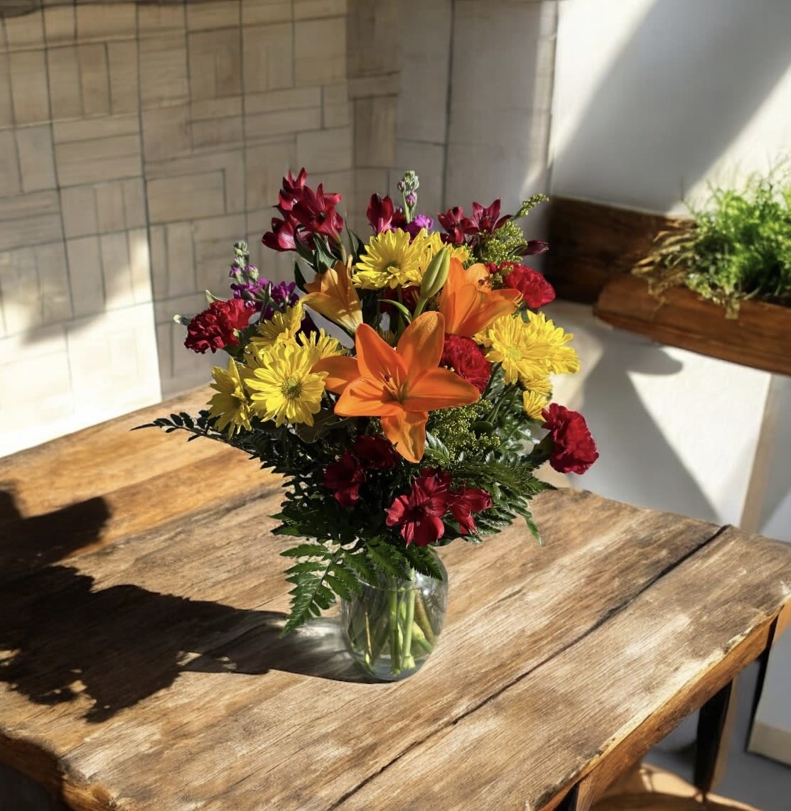 Feel Better Soon Bouquet - A bright little boost to lift spirits and send healing wishes.  The Feel Better Soon Bouquet is designed to bring comfort, color, and a smile when it’s needed most. Sunny yellows, warm oranges, and rich reds come together in a joyful mix of fresh lilies, daisies, and seasonal blooms—each one chosen to radiate positivity and care.  Whether you’re sending encouragement, love, or a gentle reminder that brighter days are ahead, this bouquet says “we’re thinking of you” in the most heartfelt way.