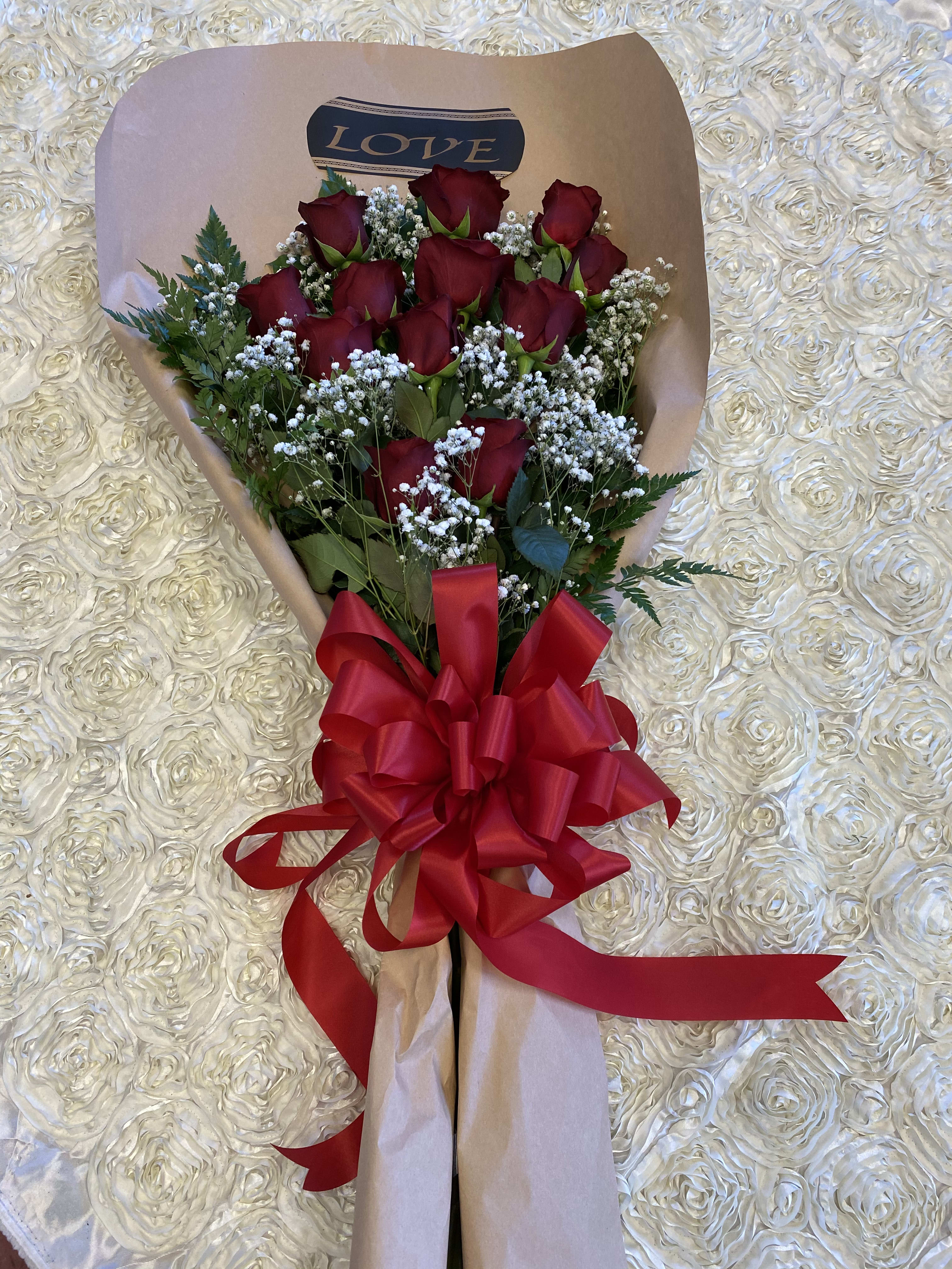 #128 - Wrapped with Love - One dozen of red roses wrapped in brown paper with a red bow. 