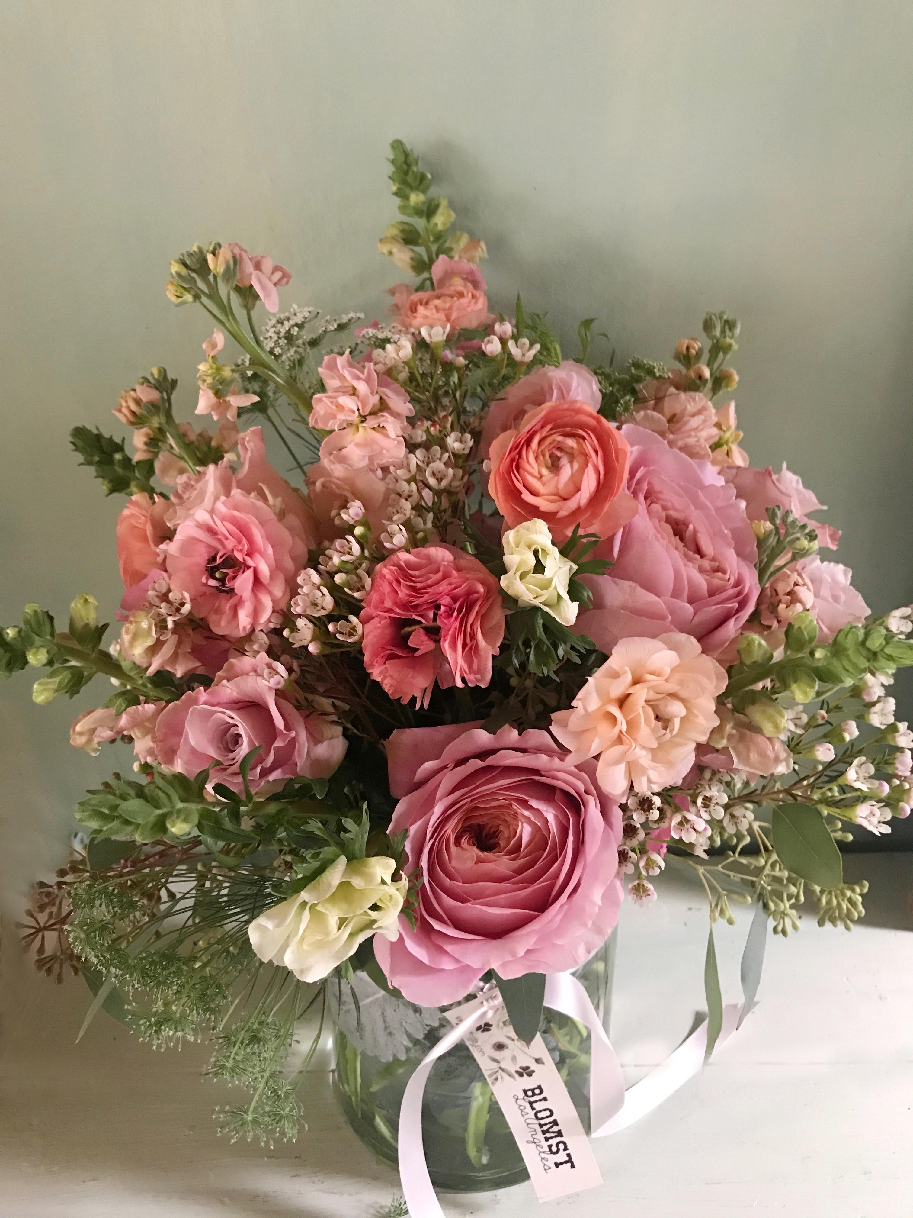 The Secret garden - Natural and organic garden like arrangement of seasonal pink flowers, always containing roses, stock &amp; snapdragons. Feminine and elegant, perfect for the fashionable woman, for a day of romance, Valentine's Day or Mothers Day. Placed in a clear 6 by 6" vase.