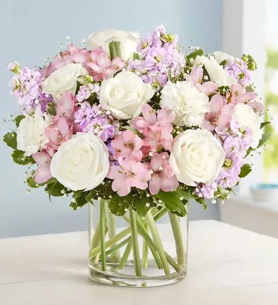 Elegant Blush  Bouquet - Our elegant bouquet in shades of blush pink and creamy white brings all the charm of a rustic country garden to the people you care about. Cascading blooms are hand-gathered with lush greenery and designed in a clear cylinder vase, creating a beautiful gift that delights with every detail.