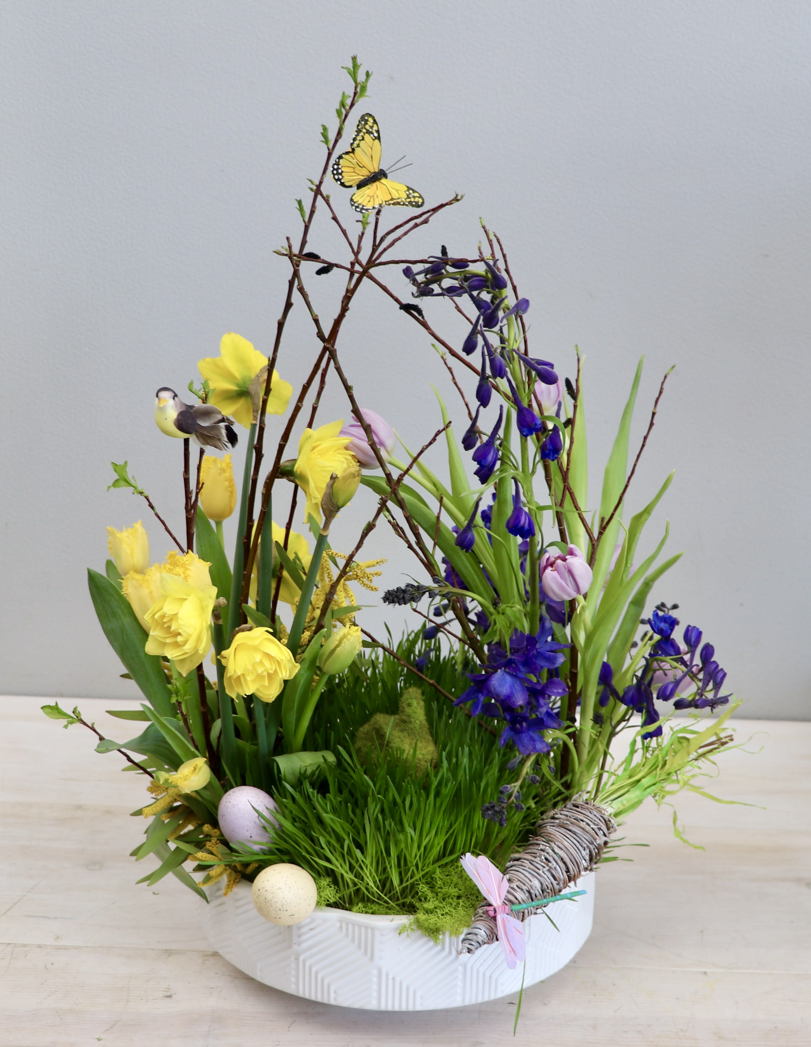 Bunny Bouquet - West Hollywood Flowers  - An elegant Easter blooms bouquet, featuring a blend of fresh lavender tulips, yellow daffodils, blue delphinium, and lush grass. The standard size stands about 2ft tall, for more blooms be sure to upgrade! 